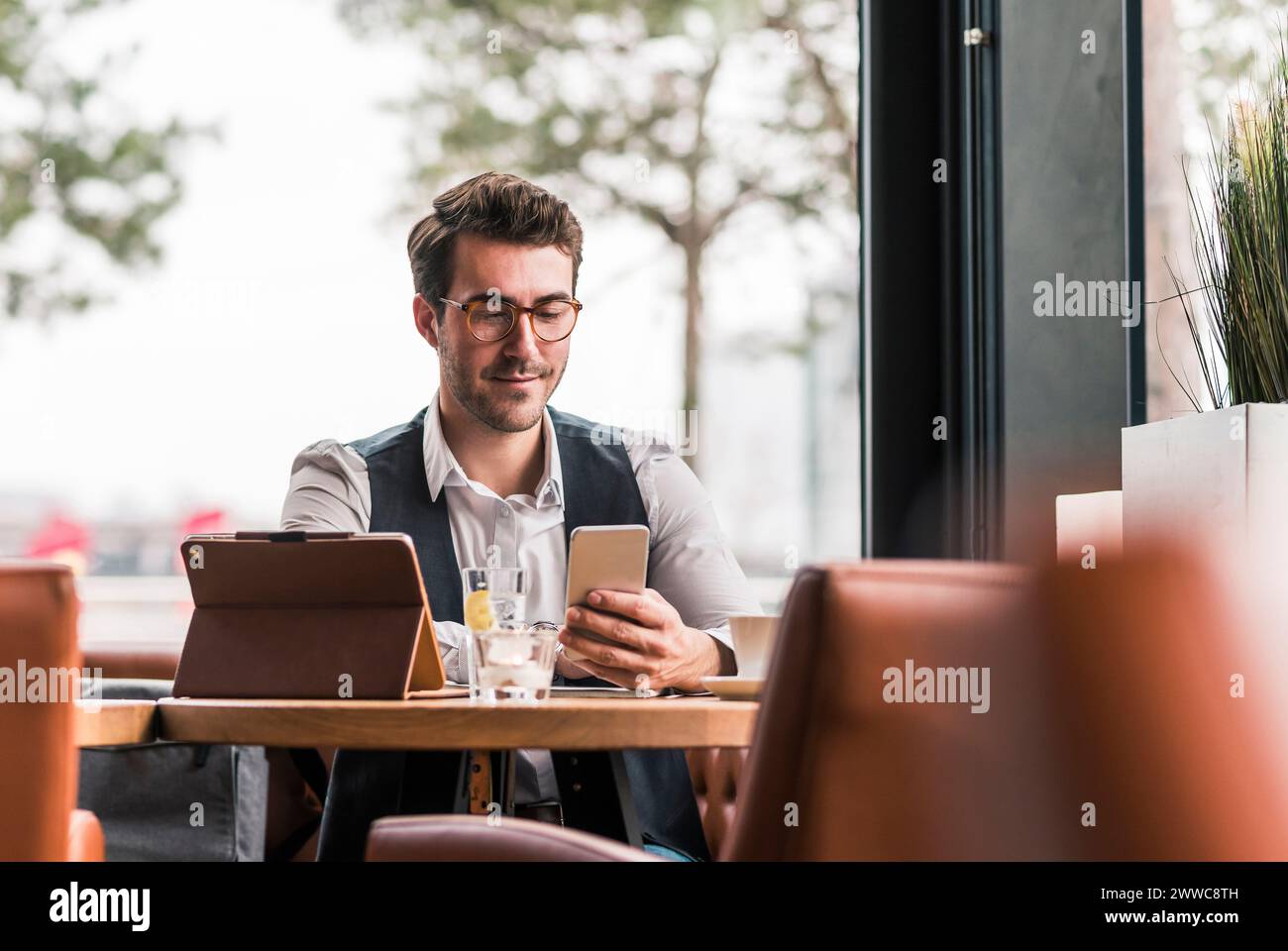 Geschäftsmann mit Smartphone im Café Stockfoto