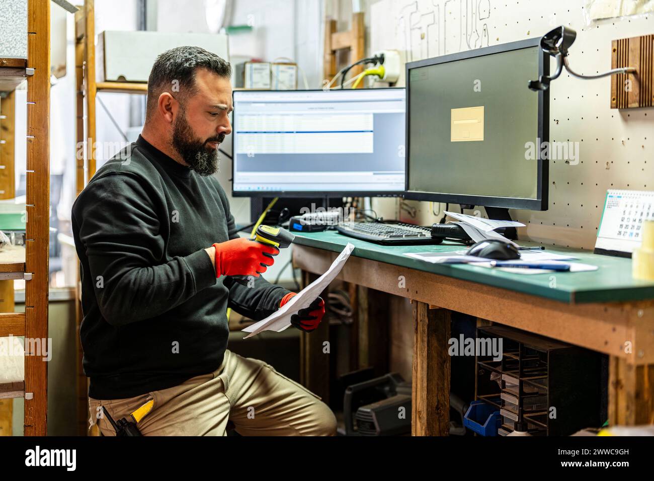 Dispatcher scannt Barcodes in der Nähe des Computers am Schreibtisch Stockfoto