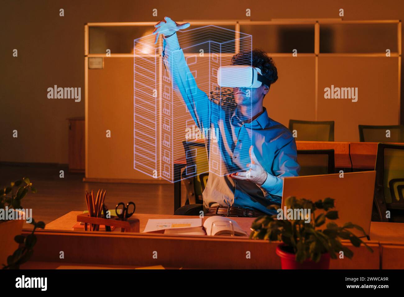 Architekt trägt Virtual-Reality-Simulator und untersucht die Blueprint-Schnittstelle im Büro Stockfoto