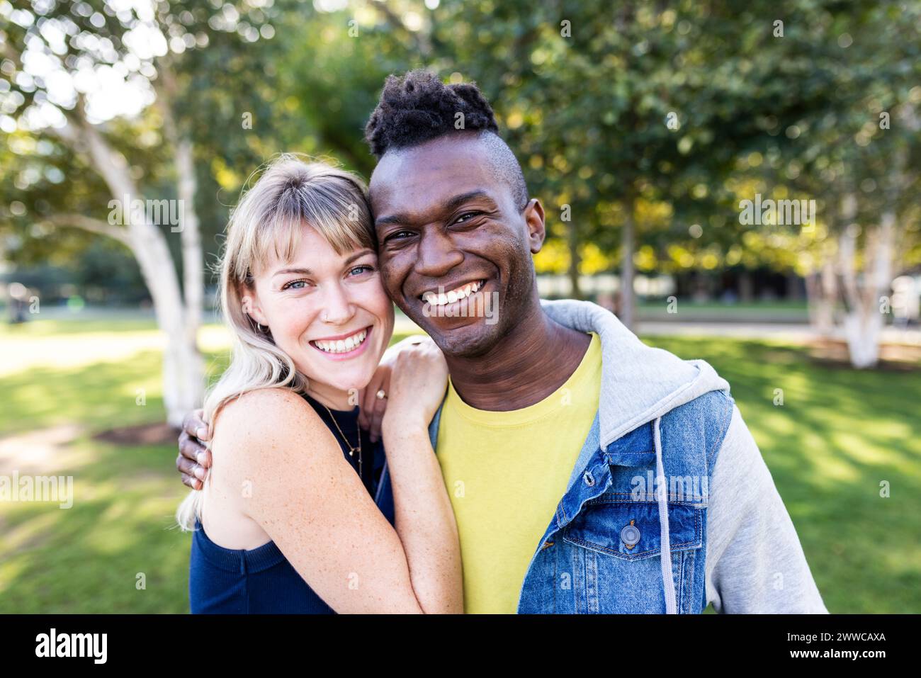 Lächelnde multirassische Freunde mit Wange an Wange im Park Stockfoto