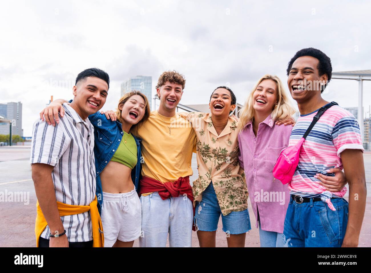 Gruppenfoto von glücklichen jungen Freunden mit farbenfroher Kleidung, die in die Kamera lächelt Stockfoto