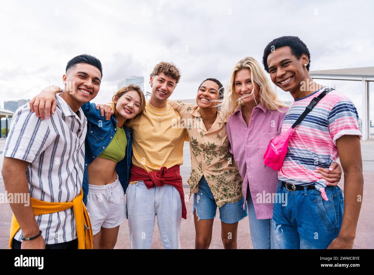Gruppenfoto von glücklichen jungen Freunden mit farbenfroher Kleidung, die in die Kamera lächelt Stockfoto