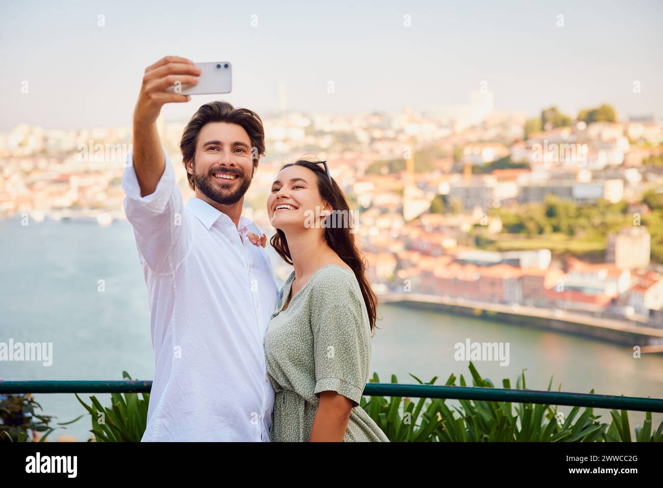 Ein lächelnder junger Mann macht Selfie mit der Frau über das Smartphone Stockfoto