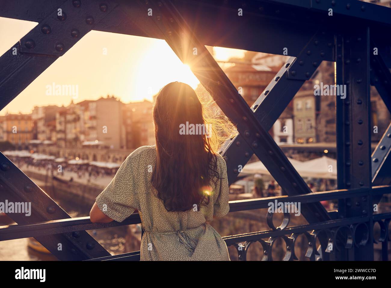 Eine junge Frau, die an der Dom Luis-Brücke in Porto, Portugal steht Stockfoto