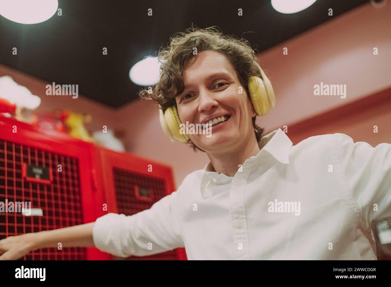 Glückliche Frau mit kabellosen Kopfhörern, die Musik hört Stockfoto