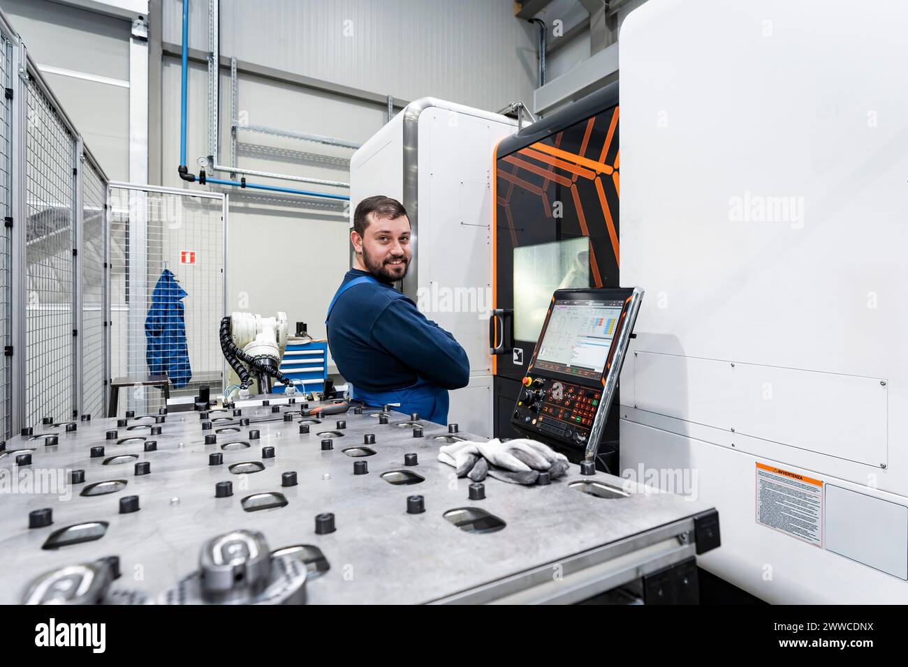 Lächelnder Wartungstechniker, der in einer modernen Fabrik arbeitet Stockfoto