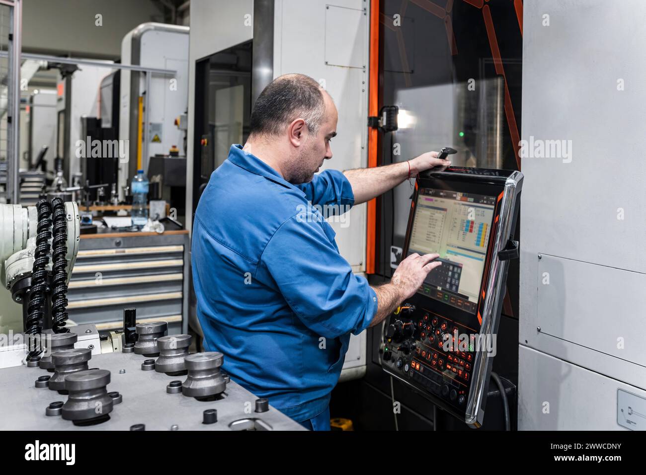 Wartungstechniker, der moderne Maschinen im Werk betreibt Stockfoto
