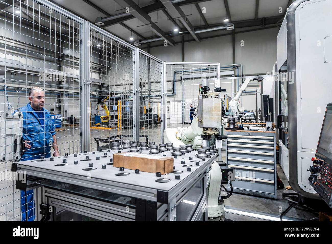 Wartungstechniker beobachtet Roboterarm in einer modernen Fabrik Stockfoto