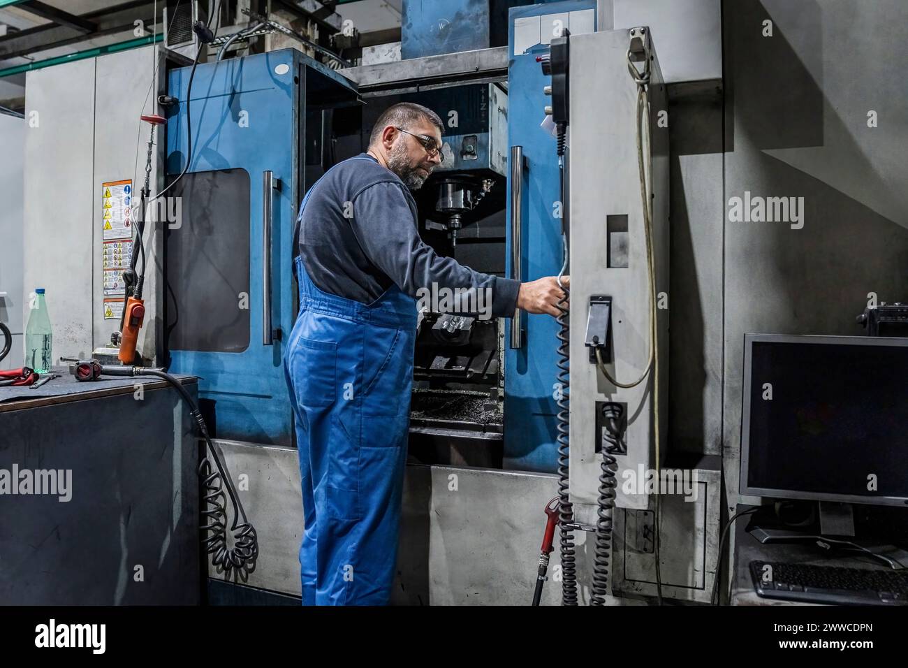 Ausgereifter Techniker, der Maschinen in der Industrie bedient Stockfoto