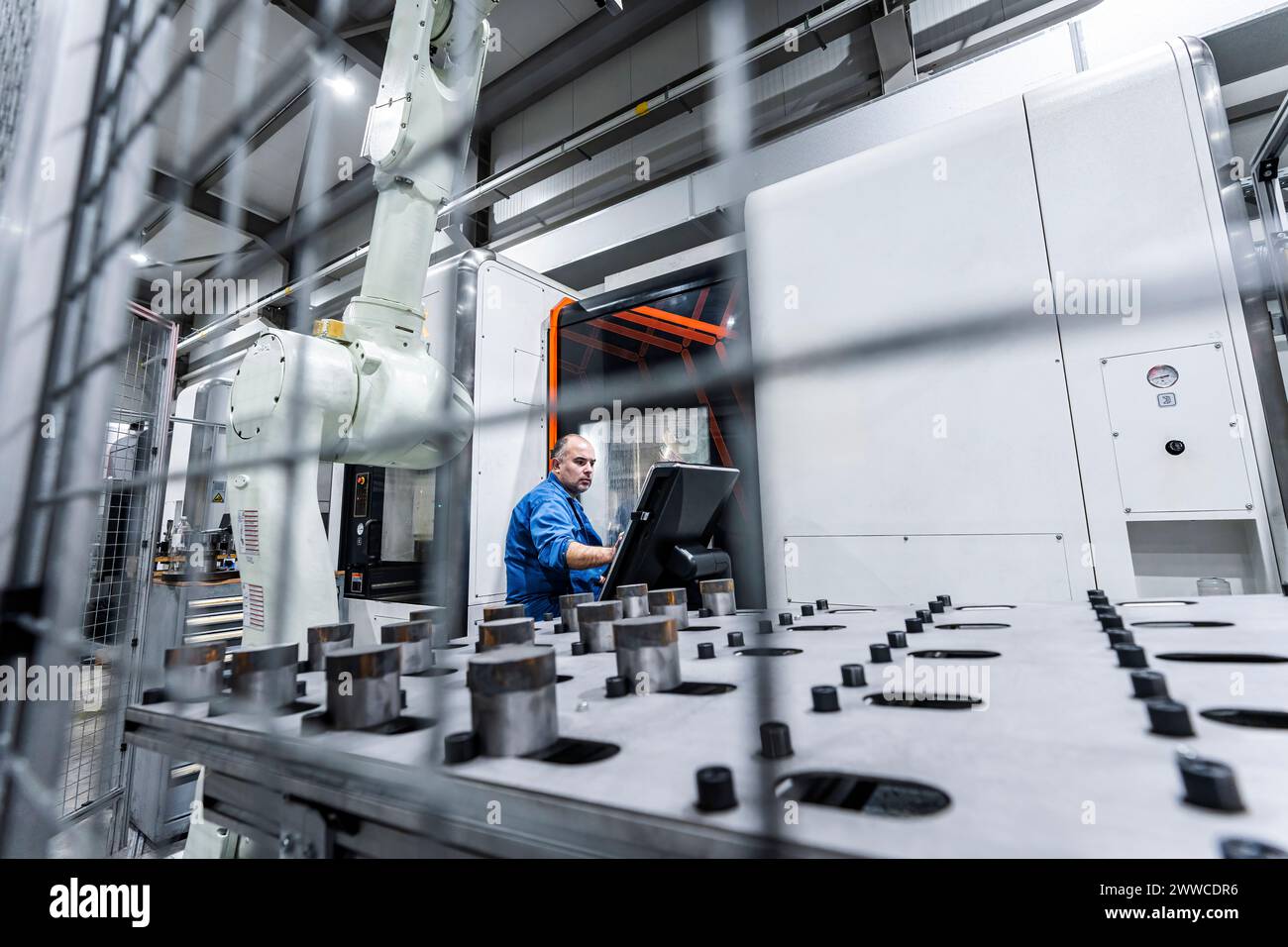 Wartungstechniker, der die CNC-Maschine im Werk bedient Stockfoto
