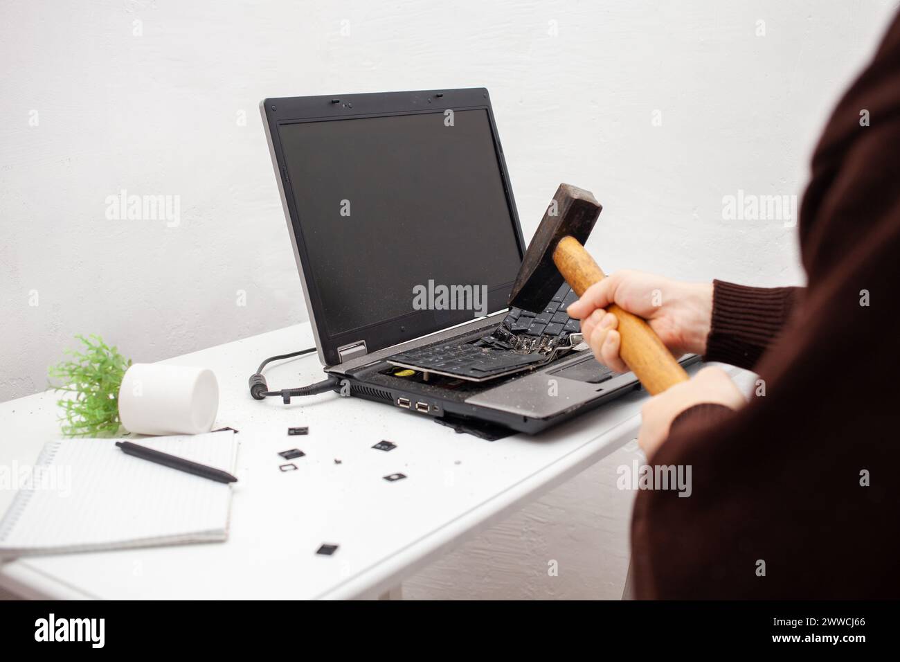 Ein Büroangestellter zerschlug einen Laptop, zerstörte einen Computer. Wut Hass, Irritation. Fehler, Bremse, Störung, will nicht funktionieren. Schlechte Emotionen. abt. Stockfoto