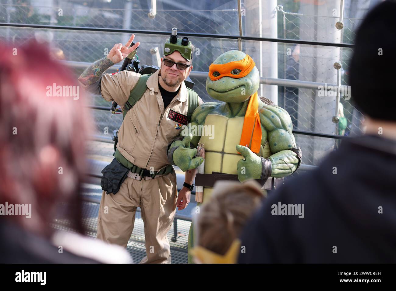 Leipzig, Deutschland. März 2024. Einer der Ghostbuster (l) trifft auf eine Teenage Mutant Ninja Turtle auf der Leipziger Buchmesse. Die Manga-Comic-Con, die auf der Buchmesse stattfindet, feiert ihr 10-jähriges Bestehen. Über 2000 Aussteller aus 40 Ländern präsentieren ihre neuen Produkte auf dem Frühjahrstreffen der Buchbranche. Quelle: Jan Woitas/dpa/Alamy Live News Stockfoto