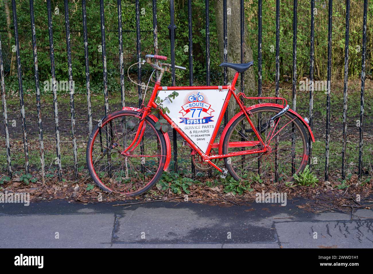 Ein altes rotes Fahrrad, das für eine Fahrradwerkstatt in Glasgow, Schottland, Großbritannien, Europa wirbt Stockfoto