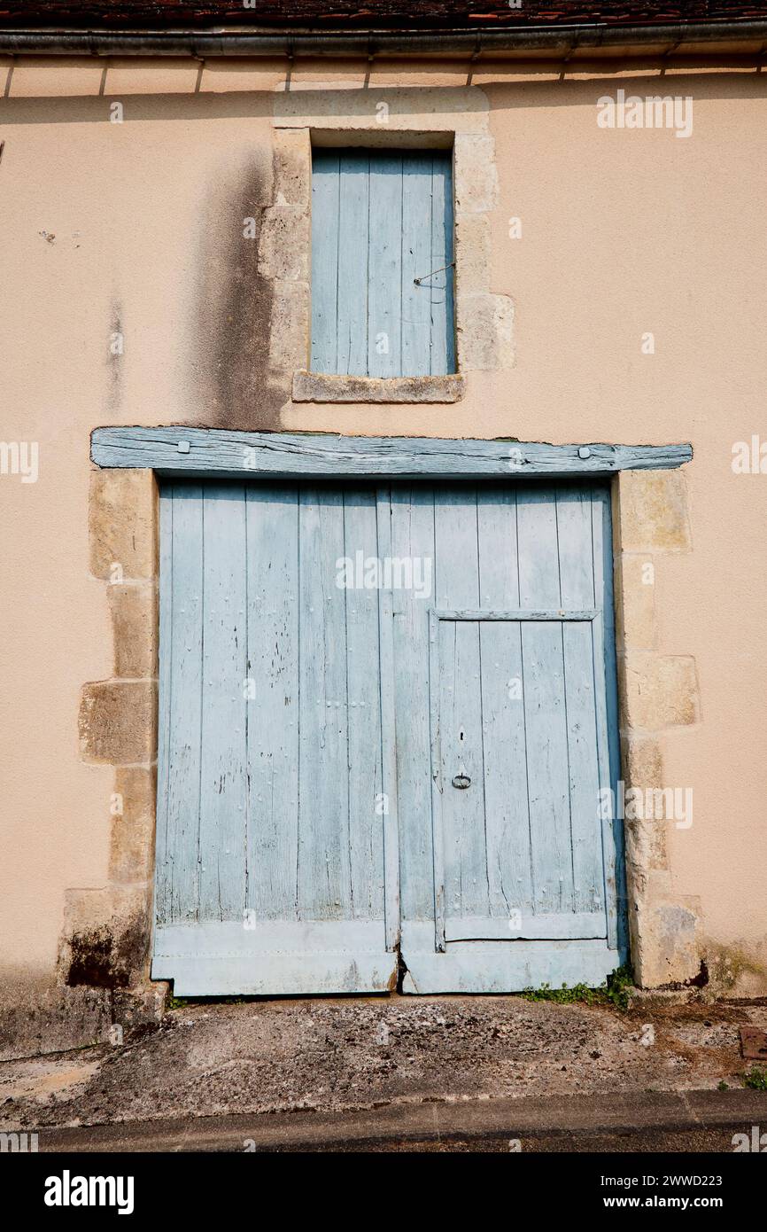 Geschlossene große Tür mit kleiner Innentür mit Fensterschaudern darüber Stockfoto