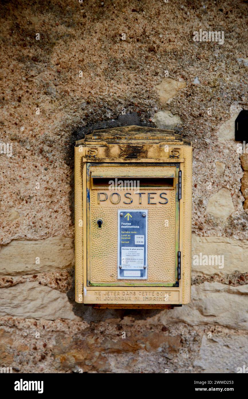 Gelber Briefkasten in Steinmauer Stockfoto