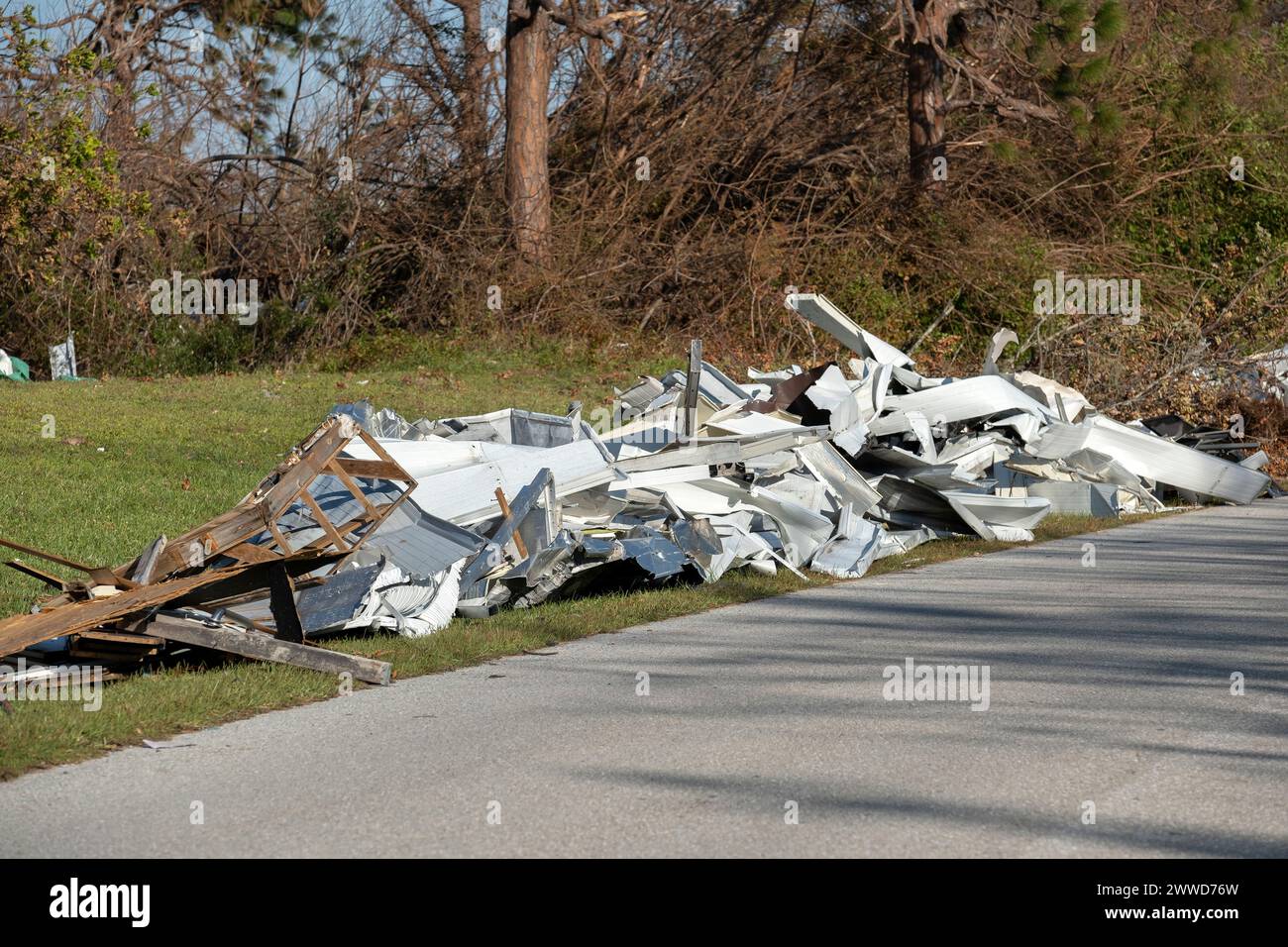 Müllhaufen auf der Straßenseite von stark beschädigten Häusern nach dem Hurrikan in Florida Wohnmobilgebiet. Folgen von Naturkatastrophen Stockfoto