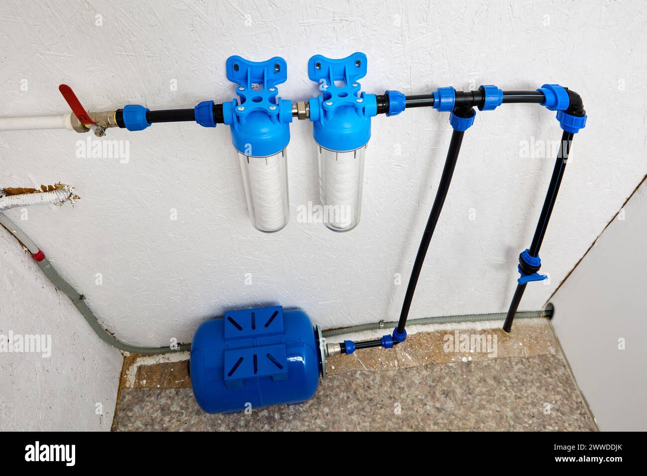 Der Versorgungsraum, der kaltes Trinkwasser vom Standort über das Hauswasserversorgungssystem erhält, ist mit einem Drucktank und einer Wasserreinigung ausgestattet Stockfoto