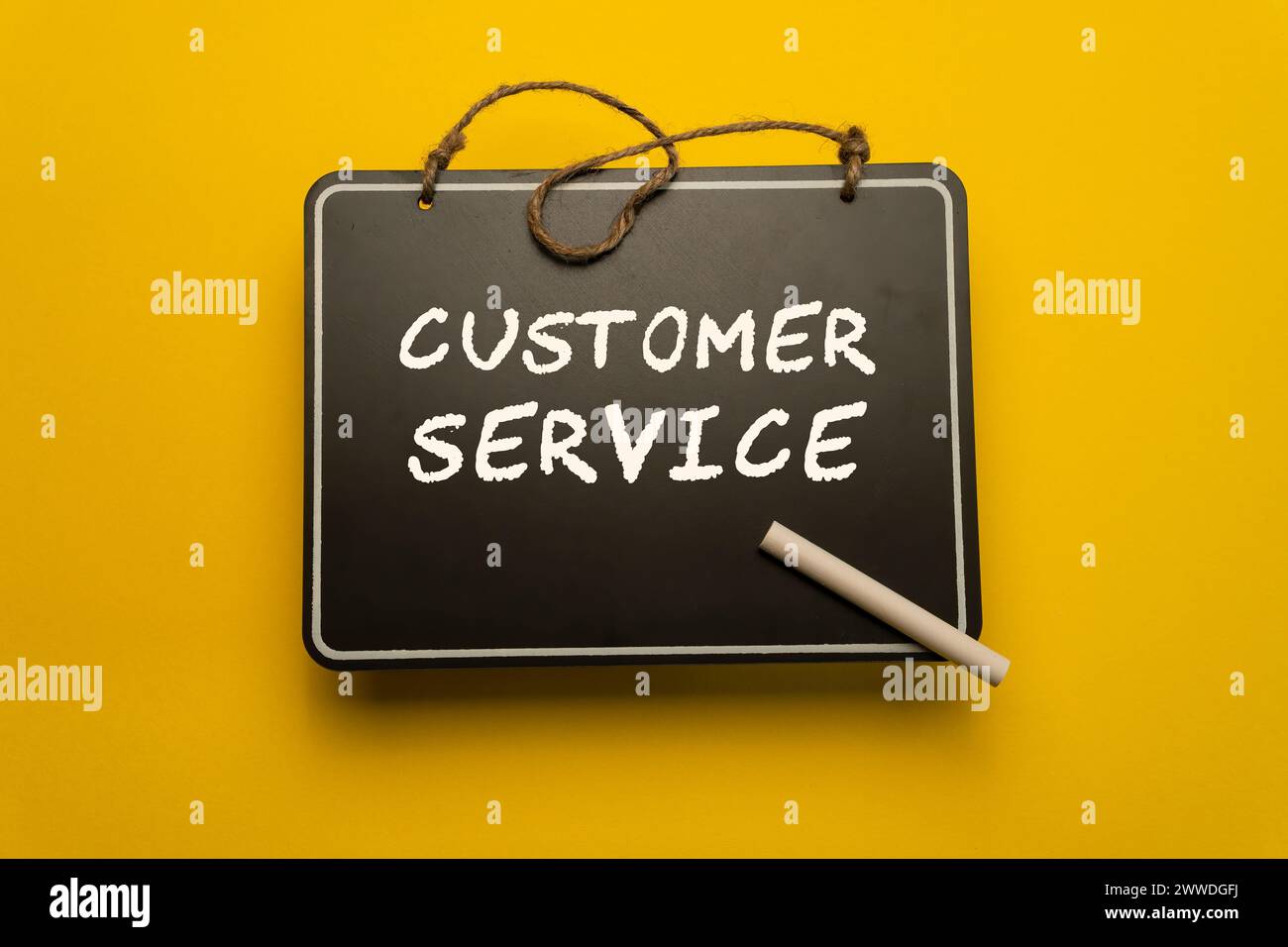 Ein kleines Schwarzes Brett für Zeitpläne auf orangem Hintergrund mit Worten für den Kundenservice Stockfoto