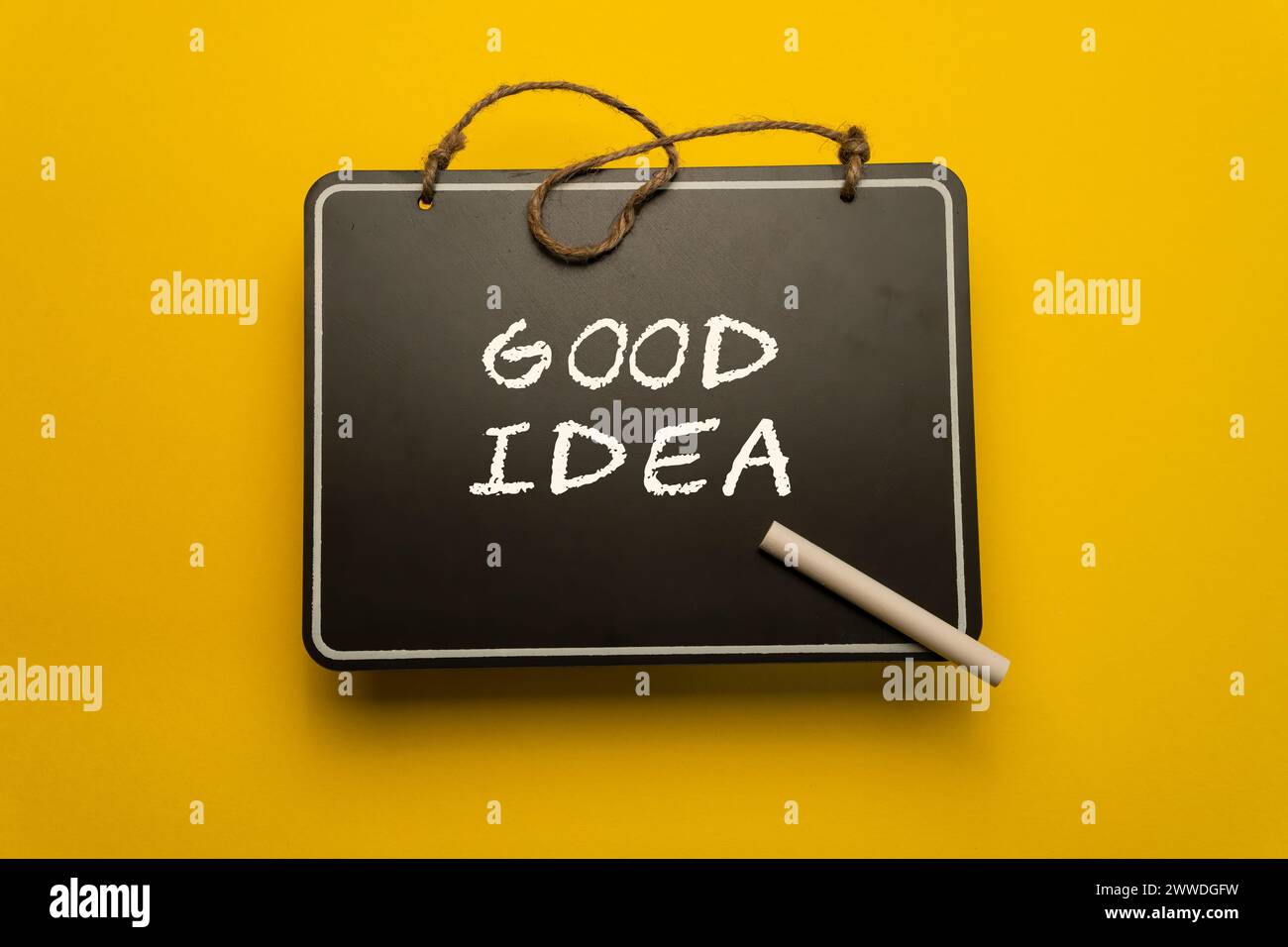 Ein kleines Schwarzes Brett für Zeitpläne auf orangem Hintergrund mit guten Ideenwörtern Stockfoto