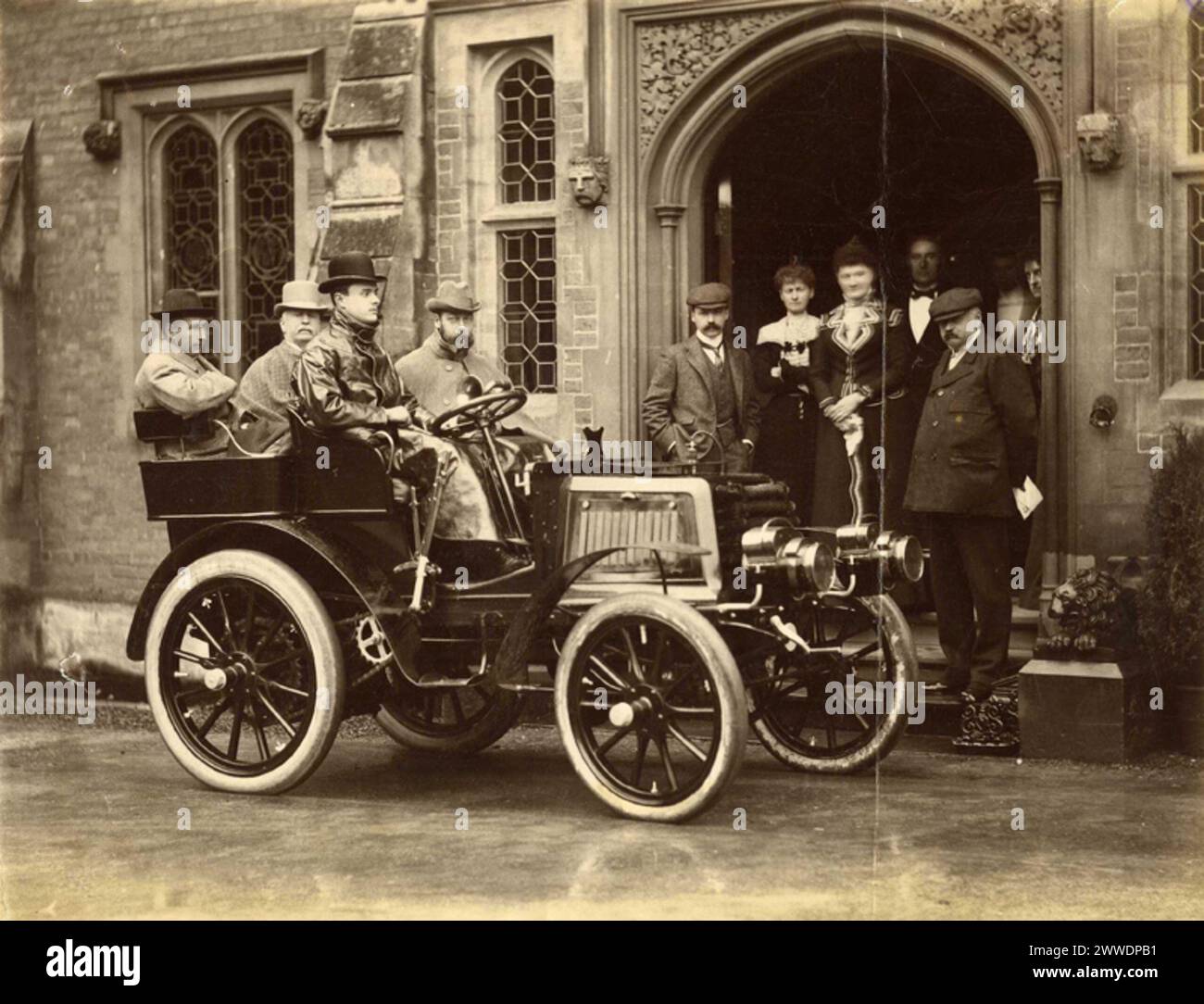 Die ursprüngliche Rolls-Beschreibung: 'Photographie of the Hon. C.S. Rolls' autocar with HRH the Duke of York, Lord Llangattock [Rolls' Vater], Sir Charles Cust and the Hon. C.S. Rolls as Occupants', aufgenommen von John Howard Preston. Charles Stewart Rolls gründete 1904 Rolls-Royce. Das Foto zeigt „The Hendre“, das gotische Herrenhaus der Familie in Monmouthshire. Datum: 1900 Sepia, Transport, Rollsroyce, Rolls, Herzoofyork, panhard, Princegeorge, Georgev, llangattock, Hendre, copy1, Charlesstewartrolle, Sircharlescust Stockfoto