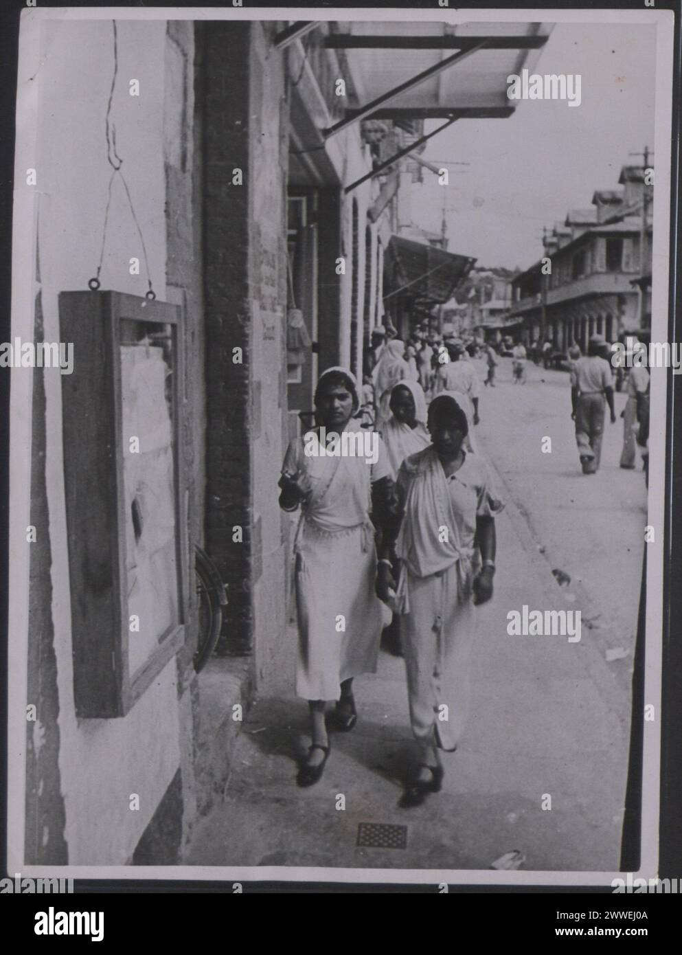 Beschreibung: Trinidad und Tobago. "Arbeitsbedingungen auf den Westindischen Inseln. Indische Frauen (aus Ostindien) gehen im spanischen Hafen einkaufen. Foto-Nr.: MOI/8705A. Offizielles Foto von Trinidad und Tobago, zusammengestellt von Central Office of Information. Handstempel des Informationsministeriums, Fotoabteilung, auf der Rückseite. Copyright of Mrs Muir, 23 Creswick Walk, London, NW11. Ort: Trinidad und Tobago Datum: [1945] karibik, karibik, karibik, karibikbewässerung Stockfoto