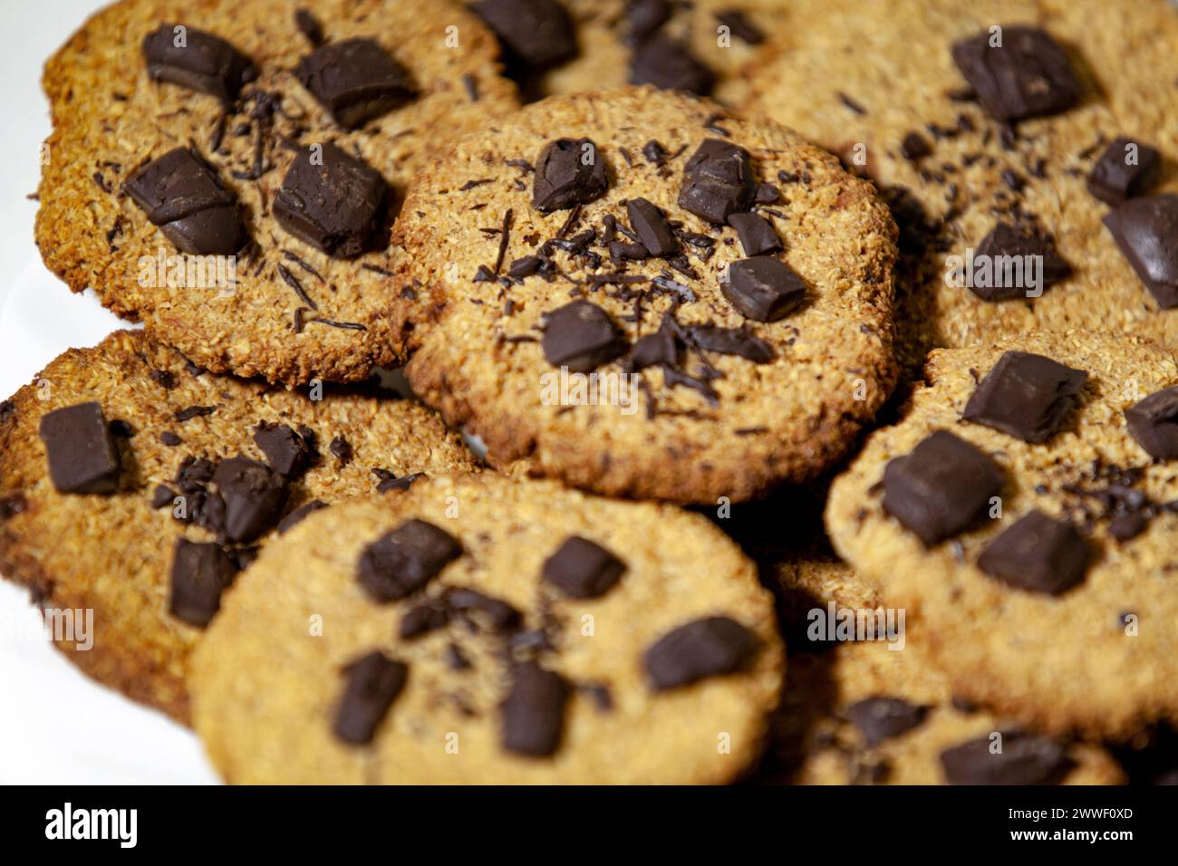 Haferkekse mit Schokolade. Ein Haufen hausgemachter Kekse auf dem Tisch. Selektiver Fokus. Draufsicht. Stockfoto