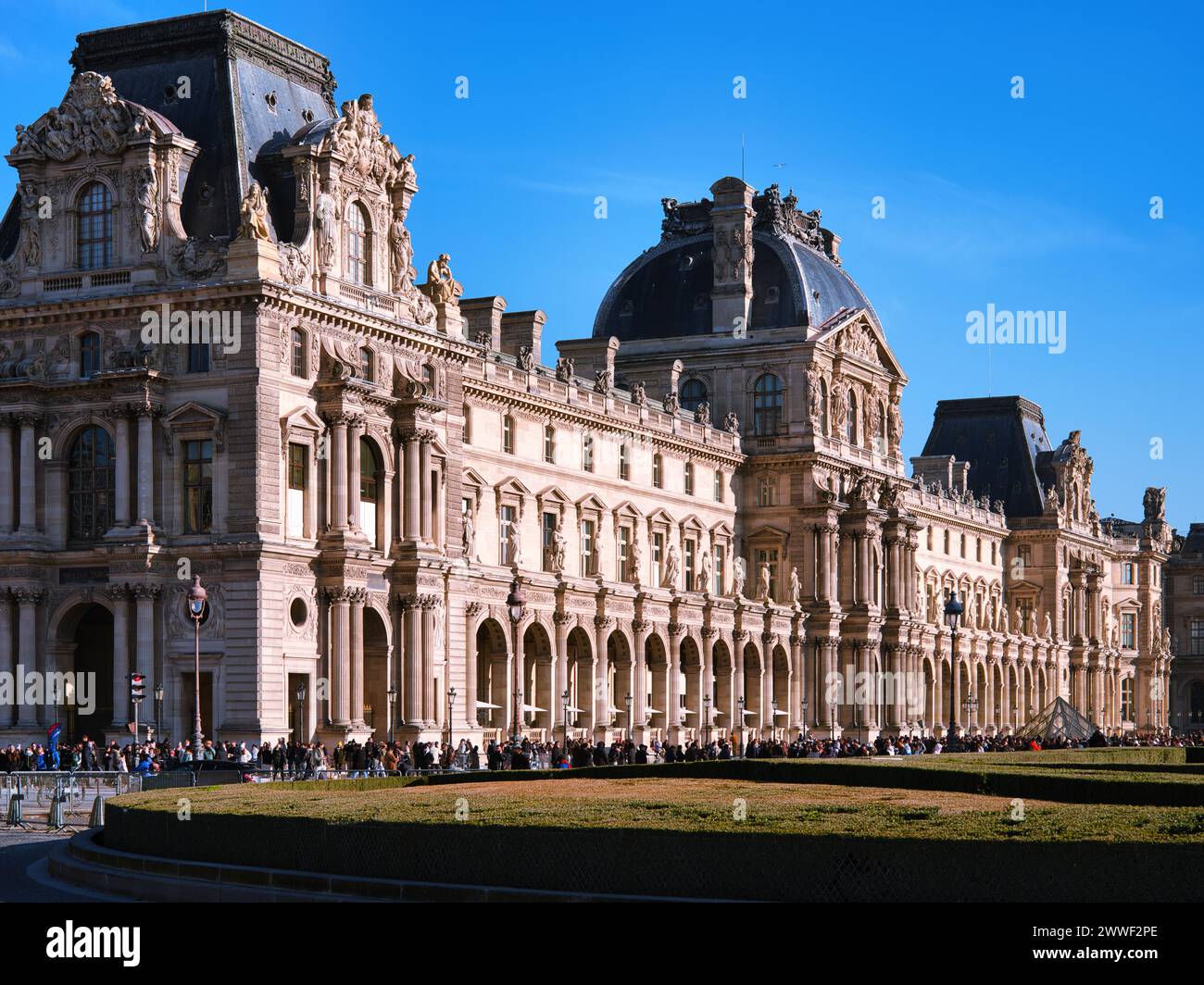 Palastfassade des Louvre-Museums in Paris, Frankreich, mit verzierten historischen Flügeln und Mansarddächern unter einem blauen Himmel, ein weltberühmtes Kunstmuseum Stockfoto