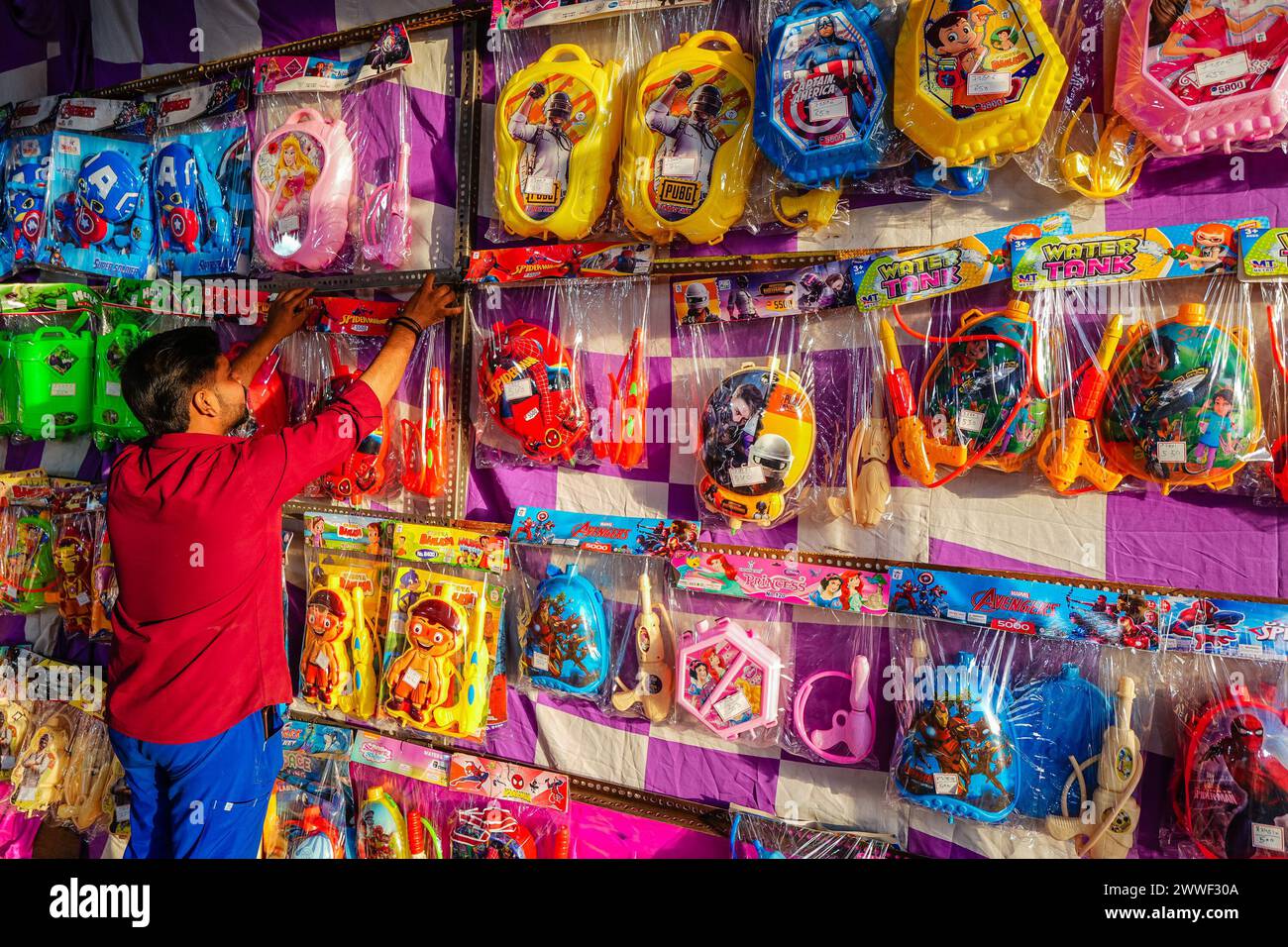 23. März 2024, Ahmedabad, Gujarat, Indien: Das Festival der Farben ist gleich um die Ecke, Märkte in der ganzen Stadt bereiten sich auf die Feierlichkeiten vor. Die Großhändler im alten Ahmedabad bereiten sich auf das Festival vor und die Märkte füllen sich mit einer Vielzahl von Wasserpistolen, um Holi zu erwarten. In Indien hergestellte Holi-Spielzeuge sind im Vergleich zu chinesischen Spielzeugen populärer geworden. Sie präsentieren neue Pichkaris-Designs vor ihren Geschäften und verleihen den Märkten eine festliche Atmosphäre. Eine große Auswahl an Abeer und Gulal, einschließlich Kräuterfarben, kann auf dem Markt gesehen werden. Die Preise sind um gestiegen Stockfoto