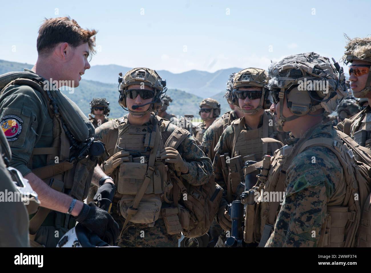 Carson Green, Linke, ein MV-22B Osprey Crew Chief, der der Marine Medium Tiltrotor Squadron (VMM) 165 (verstärkt), 15. Marine Expeditionstruppe, Briefs Marines, die der Bravo Company, Bataillon Landing Team 1/5, 15. MEU zugeteilt wurden, bevor sie die Ospreys während des Trainings im Marine Corps Base Camp Pendleton, Kalifornien, einschifften. März 2024. Das Marine Corps brachte die MV-22 am 8. März 2024 in den Flugstatus zurück. VMM-165 (rein.) Führt eine gezielte, progressive Ausbildung durch, die sich auf die Wiedereingliederung der MV-22 in die Marine Air-Ground Task Force der 15. MEU als Piloten und Flugbesatzungen A konzentriert Stockfoto
