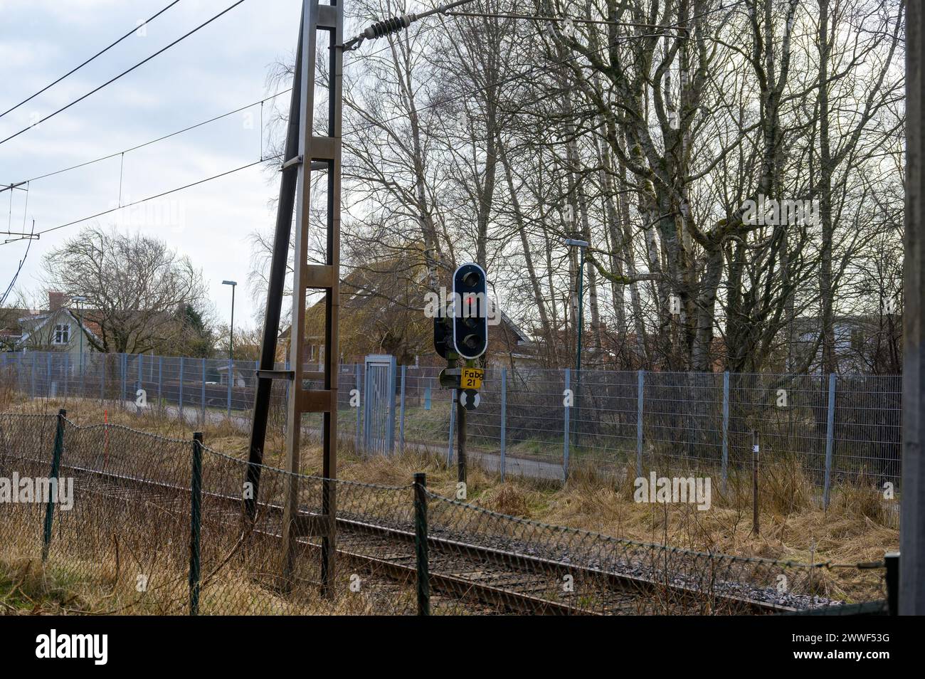 Eisenbahngleis mit beidseitigem Zaun und Signalleuchte Stockfoto