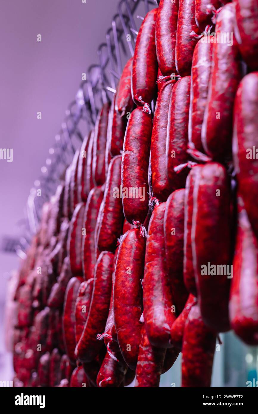 Vertikale Porträt Nahaufnahme mehrerer Chorizo-Würstchen, die von der Decke der Metzgerei hängen, schaffen eine malerische und traditionelle Stockfoto