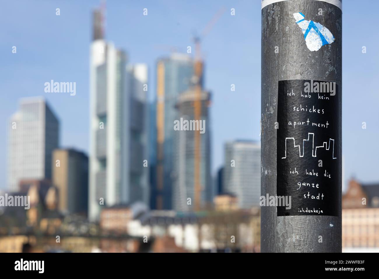 Ein Aufkleber mit der Aufschrift Ich hab kein schickes Appartment, ich hab die ganze stadt ist an einem Strassenpfahl in Frankfurt am Mainufer, Mainufer, befestigt Stockfoto