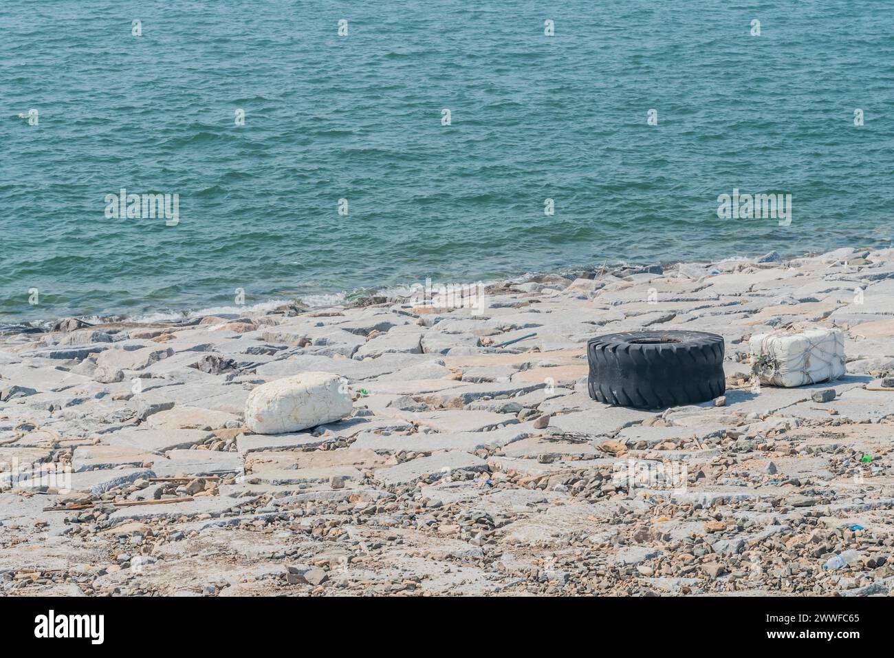 Entsorgte Reifen in der Nähe des Meeres, was die Meeresverschmutzung veranschaulicht, in Südkorea Stockfoto
