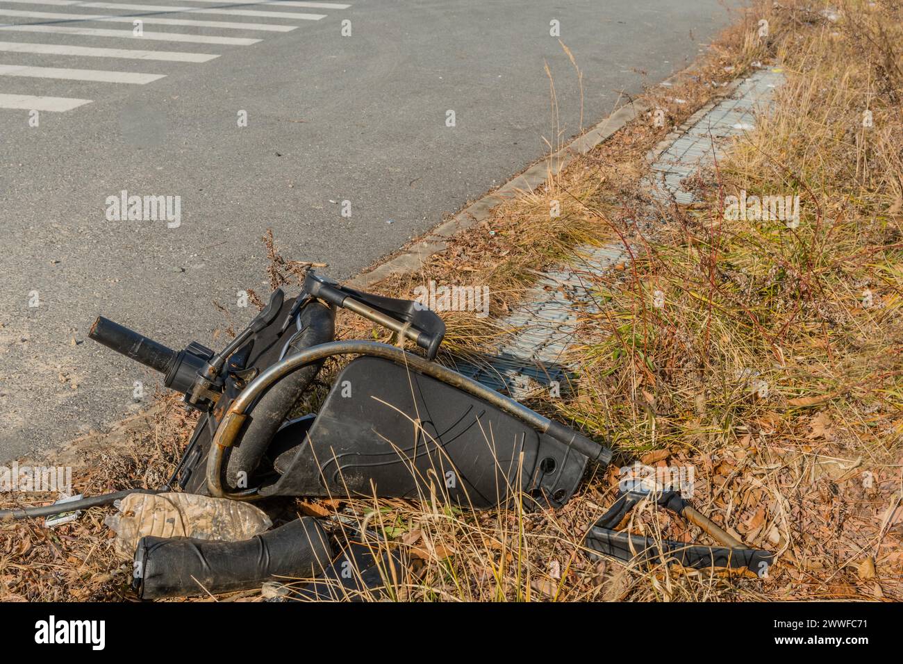 Ein kaputter Bürostuhl wurde am Straßenrand zwischen Unkraut und Gras in Südkorea abgeladen Stockfoto