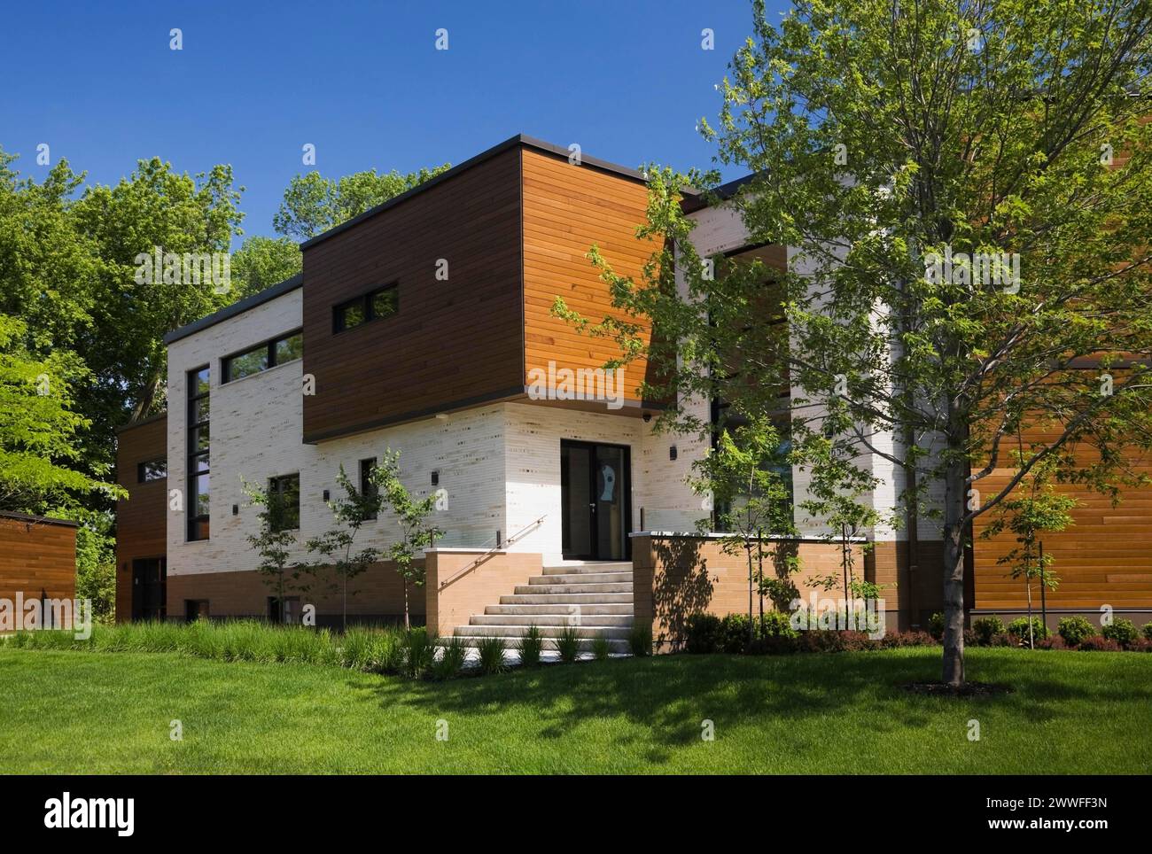 Beige Stein mit braun gebeiztem Zedernholz Moderne Wohnhausfassade im kubistischen Stil im Frühling, Quebec, Kanada Stockfoto