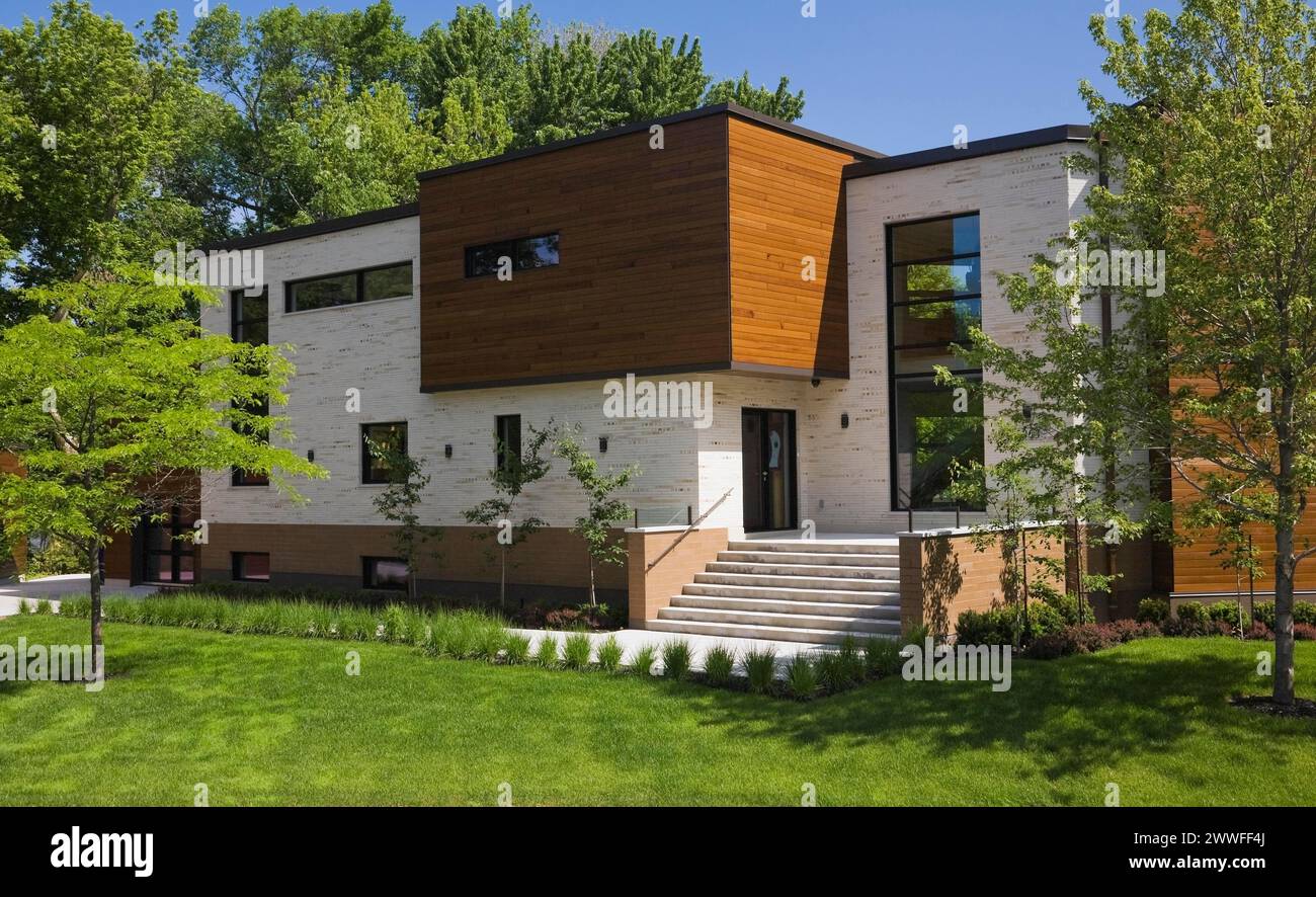 Beige Stein mit braun gebeiztem Zedernholz Moderne Wohnhausfassade im kubistischen Stil im Frühling, Quebec, Kanada Stockfoto