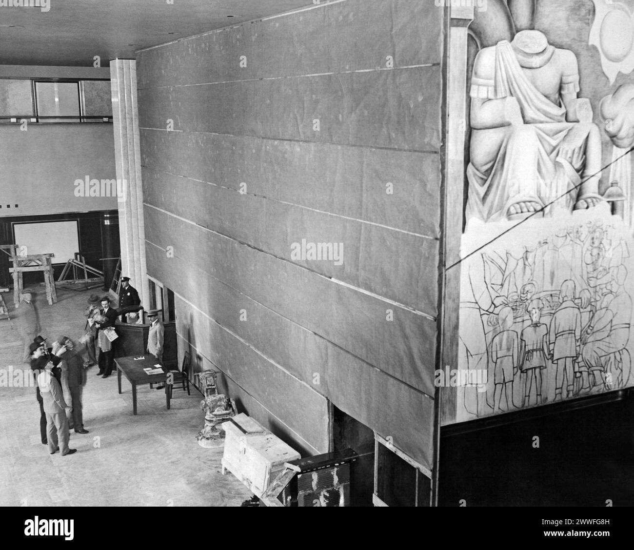 New York, New York, 10. Mai 1933 Ein großer Sackleinwand verbirgt die teilweise fertigen Gemälde an den Wänden der Lobby des neuen 72-stöckigen RCA-Gebäudes im Rockefeller Center, New York. Die Gemälde sind das Werk von Diego Rivera, einem bekannten mexikanischen Künstler, der vom Rockefeller Center wegen angeblich kommunistischer Anstiege, die in den brillanten farbigen Wandgemälden zu erkennen sind, ausgeworfen wurde. Stockfoto