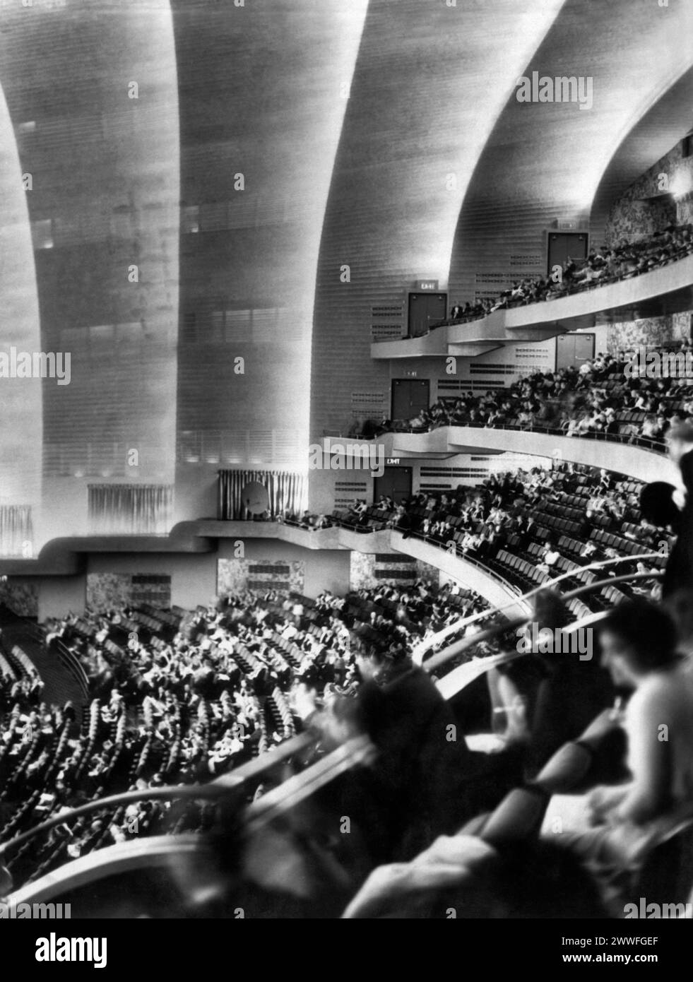 New York, New York, 27. Dezember 1932 Radio City hebt den Vorhang für das größte Theater der Welt in New York. Das mehrstufige Auditorium verleiht der Radio City Music Hall diesen modernistischen Aspekt während ihrer feierlichen Eröffnung für eine Zuschauermenge von über 6.000 Personen, war das vornehmste Publikum der ersten Nacht anwesend, als das größte Theater der Welt, das erste der 250.000.000 $ Rockefeller-Gruppe, fertiggestellt wurde. warf seine Türen auf. Es steht unter der Leitung von S. L. Rothafel, besser bekannt als roxy), der eine glitzernde Palette von Talenten für die große Eröffnung sammelte. Stockfoto