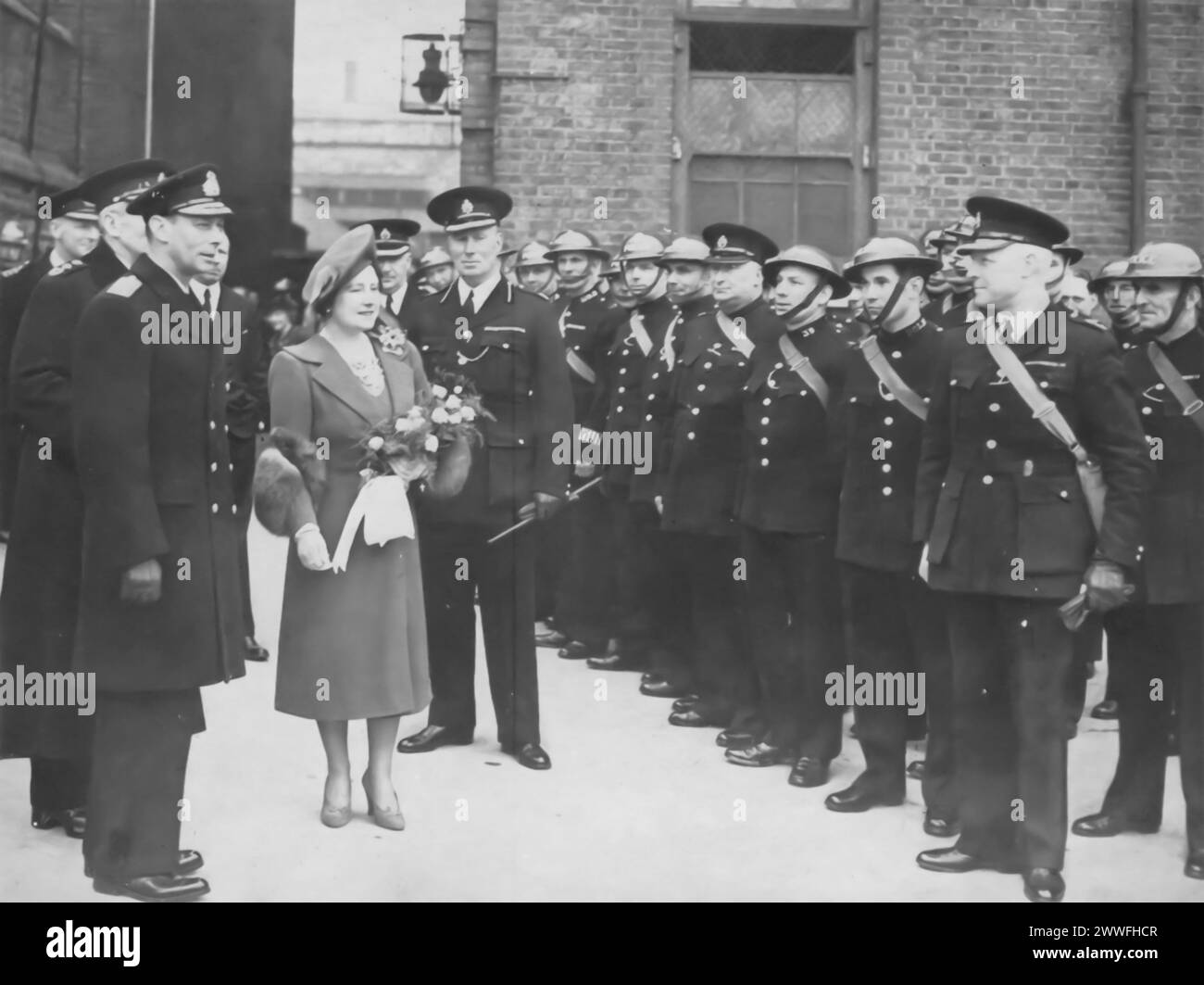 Eine Fotografie aus der Zeit um 1940 zeigt König George VI. Und Königin Elizabeth, die während des Zweiten Weltkriegs die Metropolitan Police inspizieren. Wahrscheinlich dort, um ihre Unterstützung anzubieten, zeigt dieses Bild die Bemühungen des königlichen Paares, die Moral zu stärken und Solidarität mit denen zu zeigen, die in dieser dunklen Zeit an der Heimatfront dienten. Stockfoto