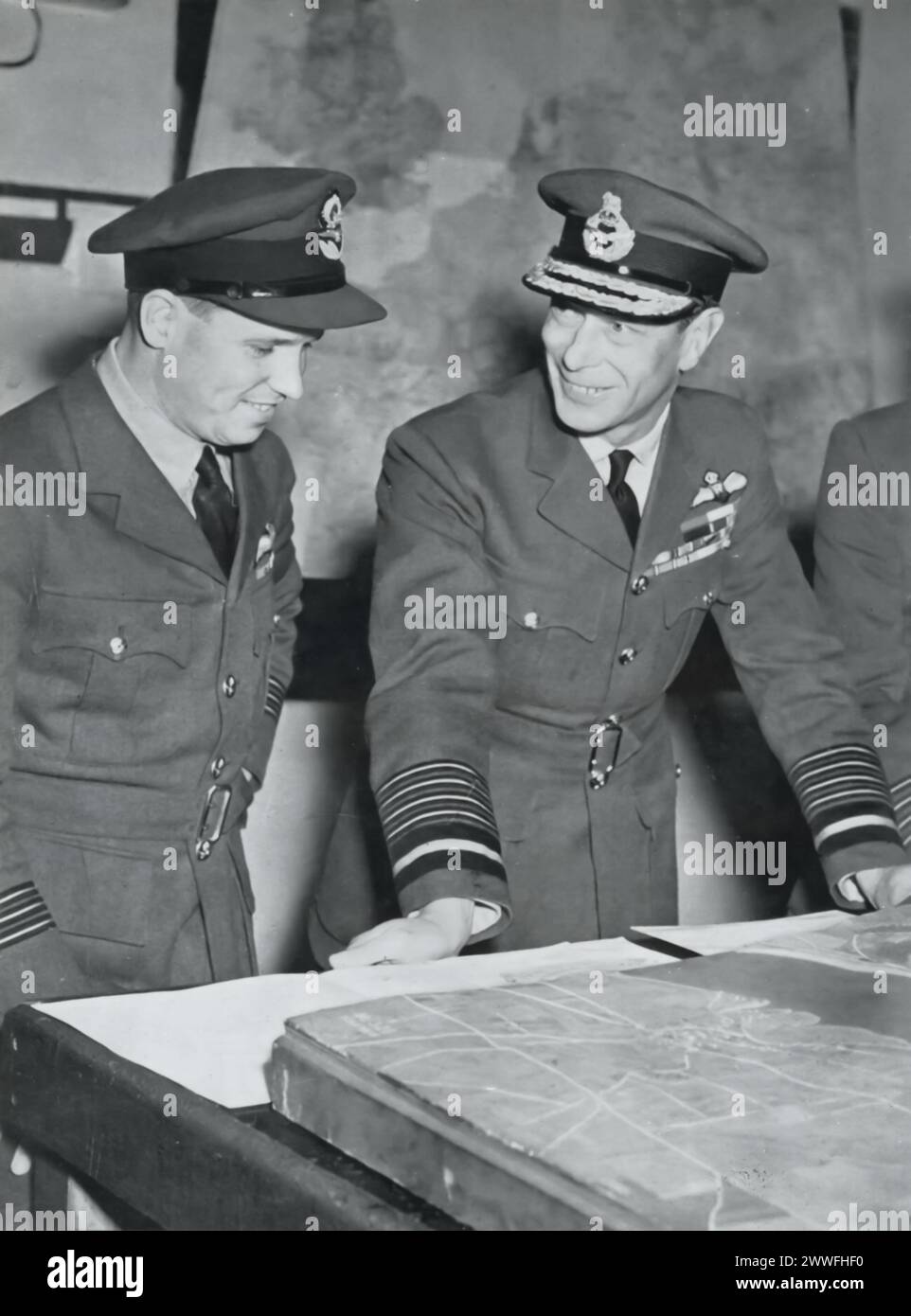 Ein Foto zeigt König George VI. Mit dem Wing-Commander Guy Gibson, der im Mai 1943 von der erfolgreichen RAF-Bomberangriff auf die großen Ruhrdämme zurückkehrte. Dieser Moment erinnert an die strategische und gewagte Operation Chastise, die im Zweiten Weltkrieg das industrielle Kernland Deutschlands erheblich beeinflusste. Stockfoto