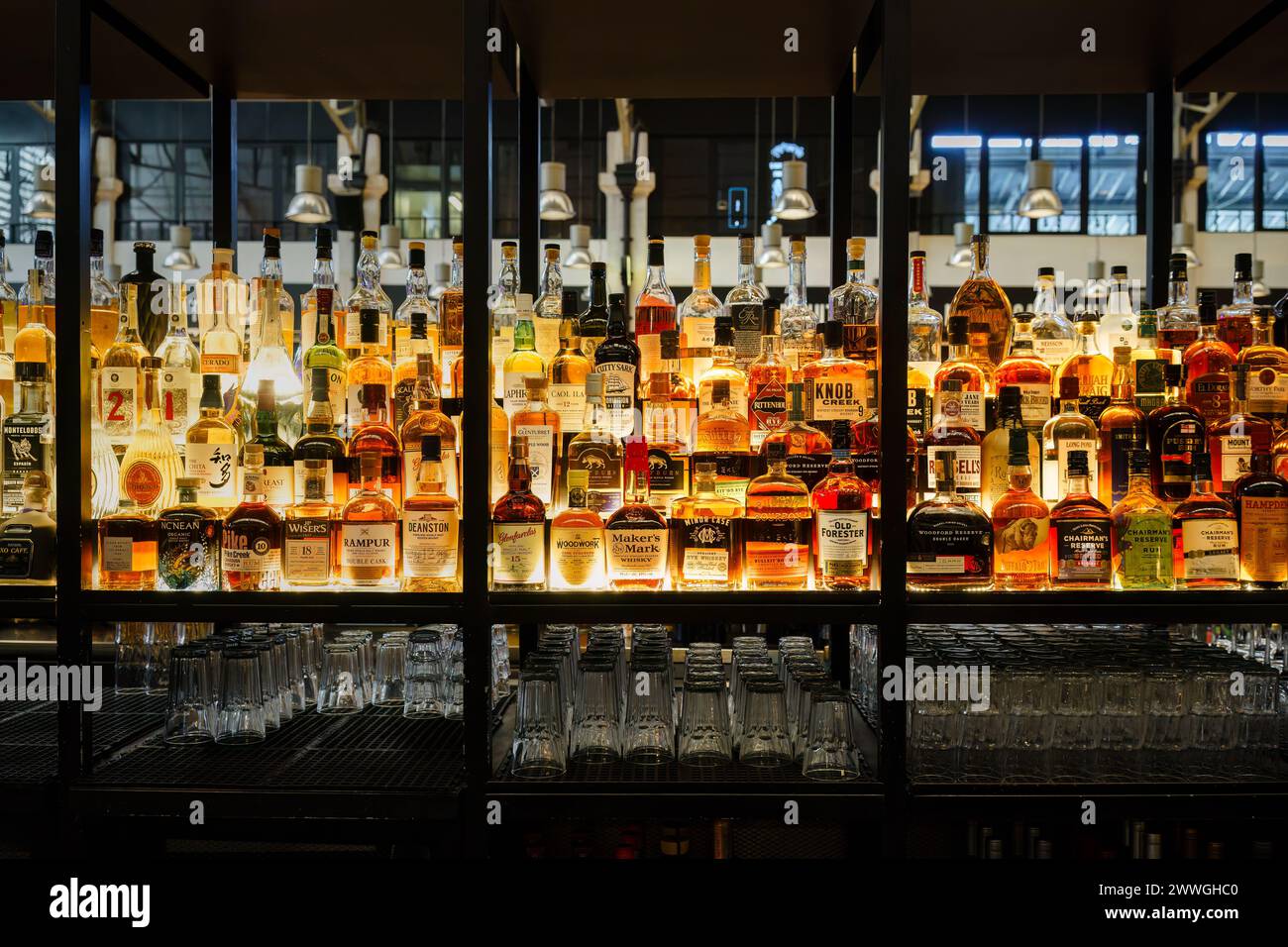 Große Auswahl an Liquors auf beleuchteten Regalen auf dem Time Out Market in Lissabon, Portugal. Februar 2024. Stockfoto