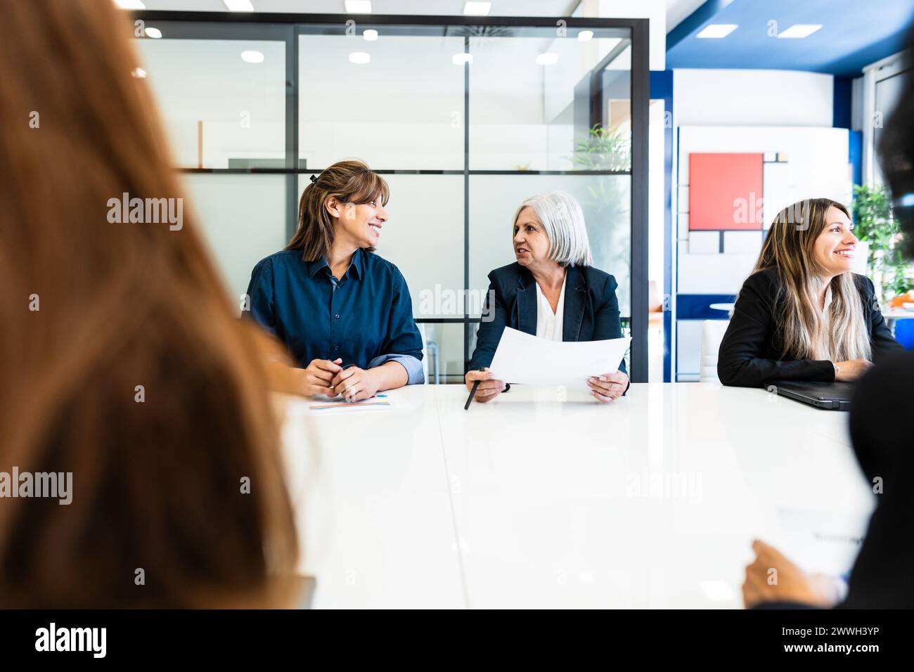 Geschäftsfrauen, die ein Briefing im Sitzungssaal eines modernen Büros machen - Brainstorming und Teamwork-Konzept Stockfoto