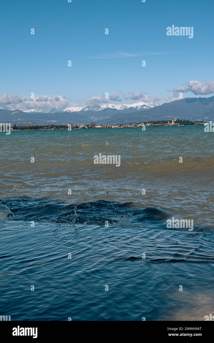 Blick über den gewellten Gardasee unter blauem Himmel mit Wolken, Sirmione, Gardasee, Italien Stockfoto