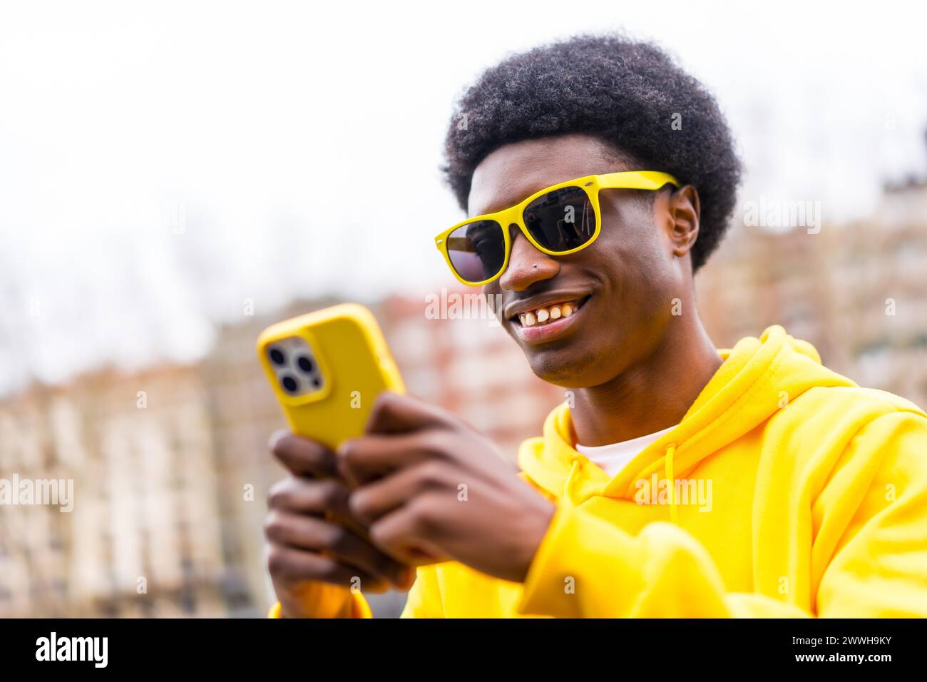 Porträt eines coolen, stylischen afrikaners, der in der Stadt das Telefon benutzt Stockfoto