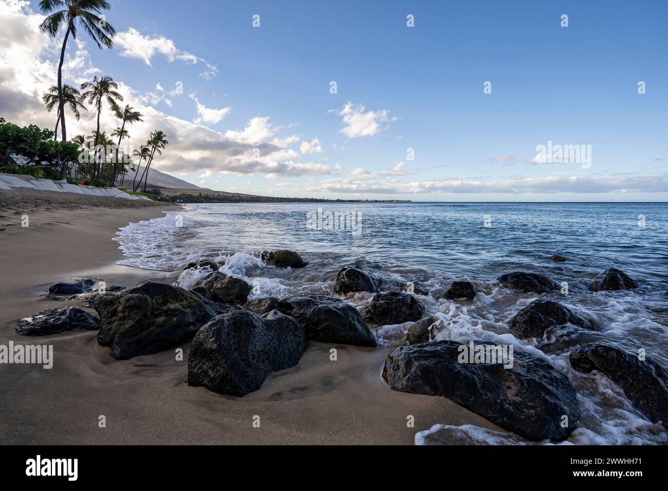 Wellen vom Pazifischen Ozean ziehen sanft über vulkanische Felsen am Kaanapali Beach in Lahaina, Hawaii auf der Insel Maui. Stockfoto