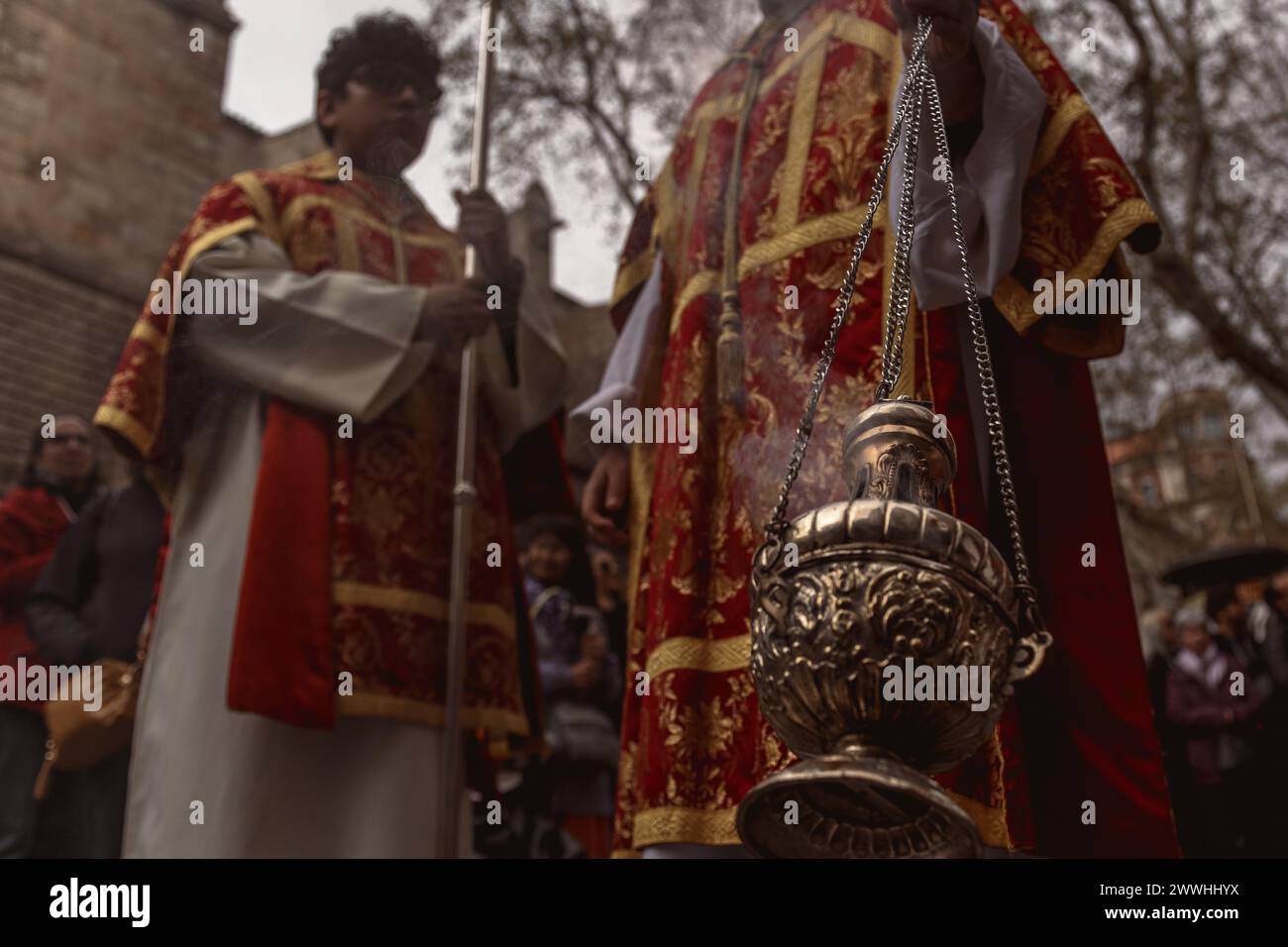 Barcelona, Spanien. März 2024. Ein Akolyt der 'Gran Poder and Macarena Esperanza'-Bruderschaft spaziert durch die Straße und winkt während der Palmensonntagsprozession in Barcelona Weihrauch. Credit: Matthias Oesterle/Alamy Live News Stockfoto