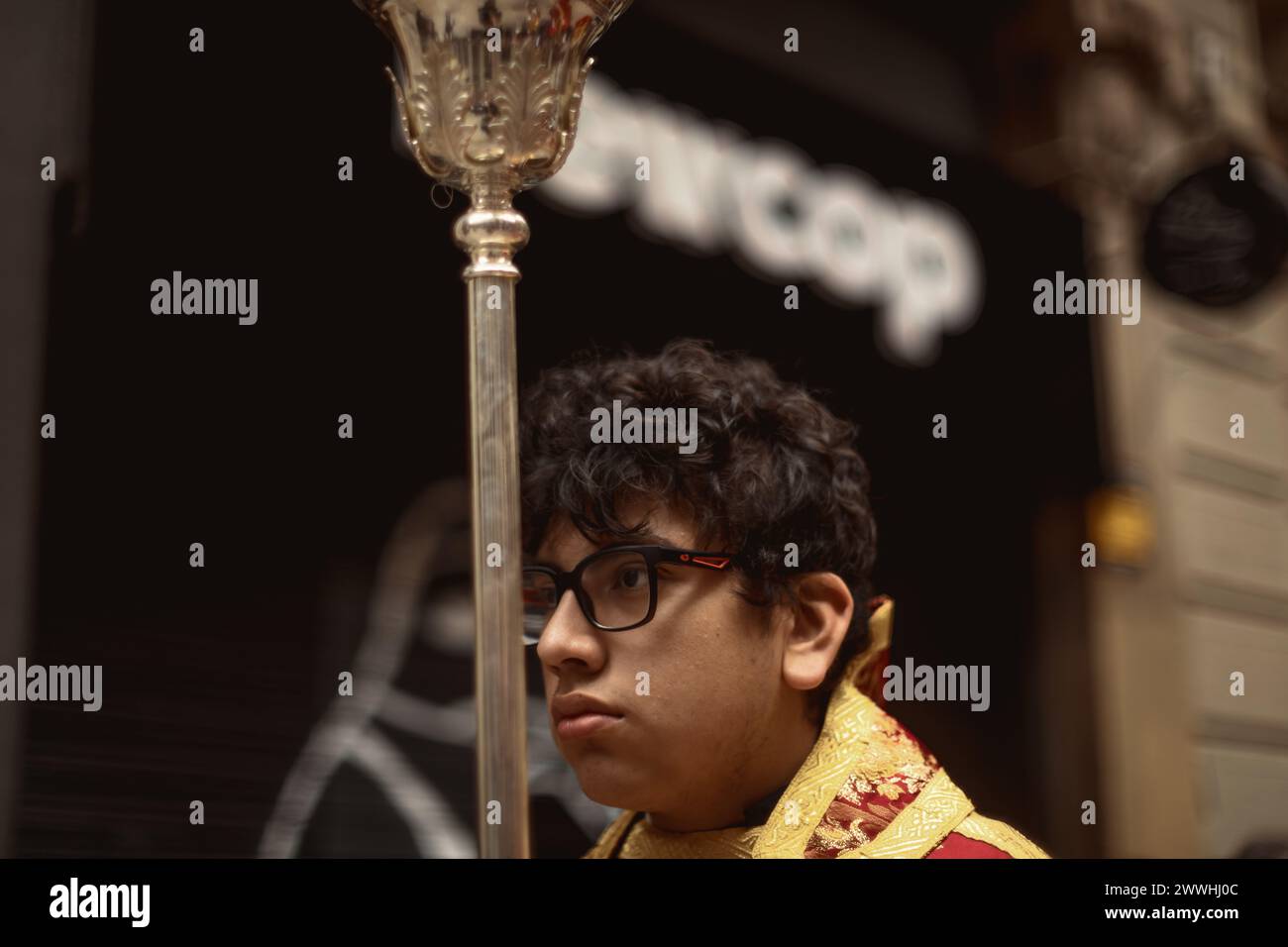 Barcelona, Spanien. März 2024. Ein junger Buße aus der Bruderschaft Gran Poder und Macarena Esperanza läuft während der Palmensonntagsprozession in Barcelona mit einem Palmenzweig durch die Straße. Credit: Matthias Oesterle/Alamy Live News Stockfoto