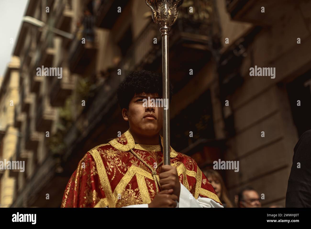 Barcelona, Spanien. März 2024. Ein junger Buße aus der Bruderschaft Gran Poder und Macarena Esperanza läuft während der Palmensonntagsprozession in Barcelona mit einem Palmenzweig durch die Straße. Credit: Matthias Oesterle/Alamy Live News Stockfoto