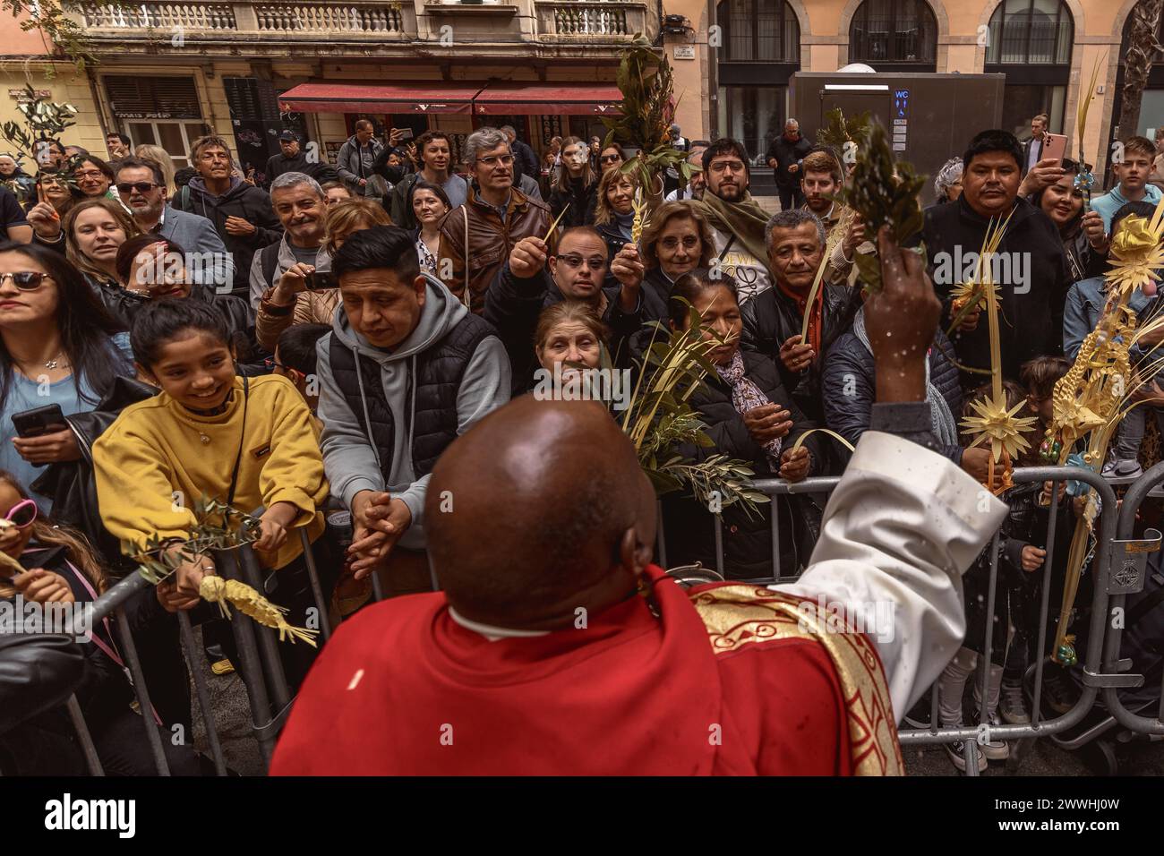 Barcelona, Spanien. März 2024. Ein Priester segnet die Gläubigen mit ihren Palmblättern am Ende der Palmensonntagsprozession in Barcelona Credit: Matthias Oesterle/Alamy Live News Stockfoto