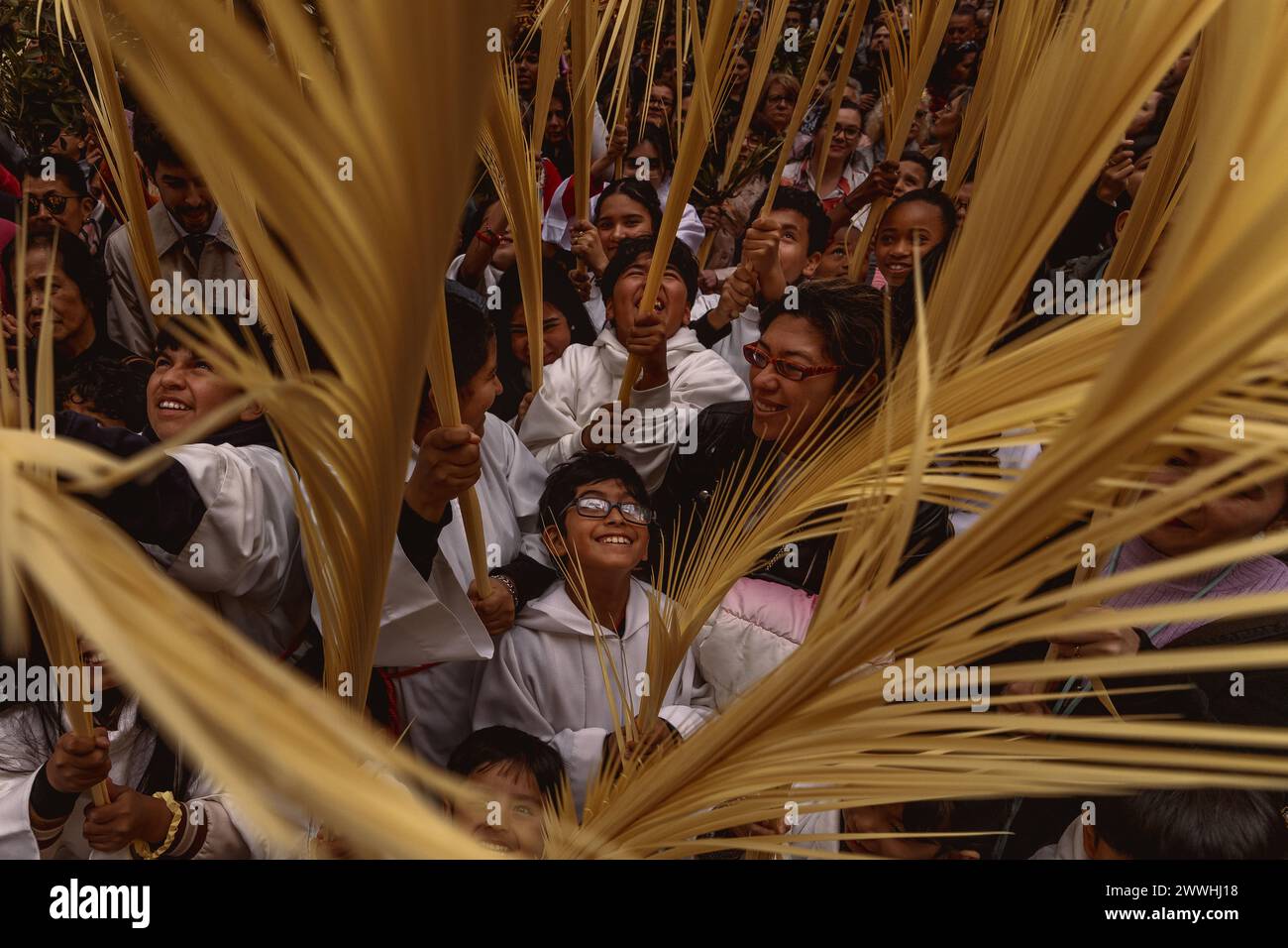 Barcelona, Spanien. März 2024. Junge Pönitenten der Bruderschaft Gran Poder und Macarena Esperanza winken Palmblätter, während der Priester sie am Ende der Palmensonntagsprozession in Barcelona segnet. Credit: Matthias Oesterle/Alamy Live News Stockfoto
